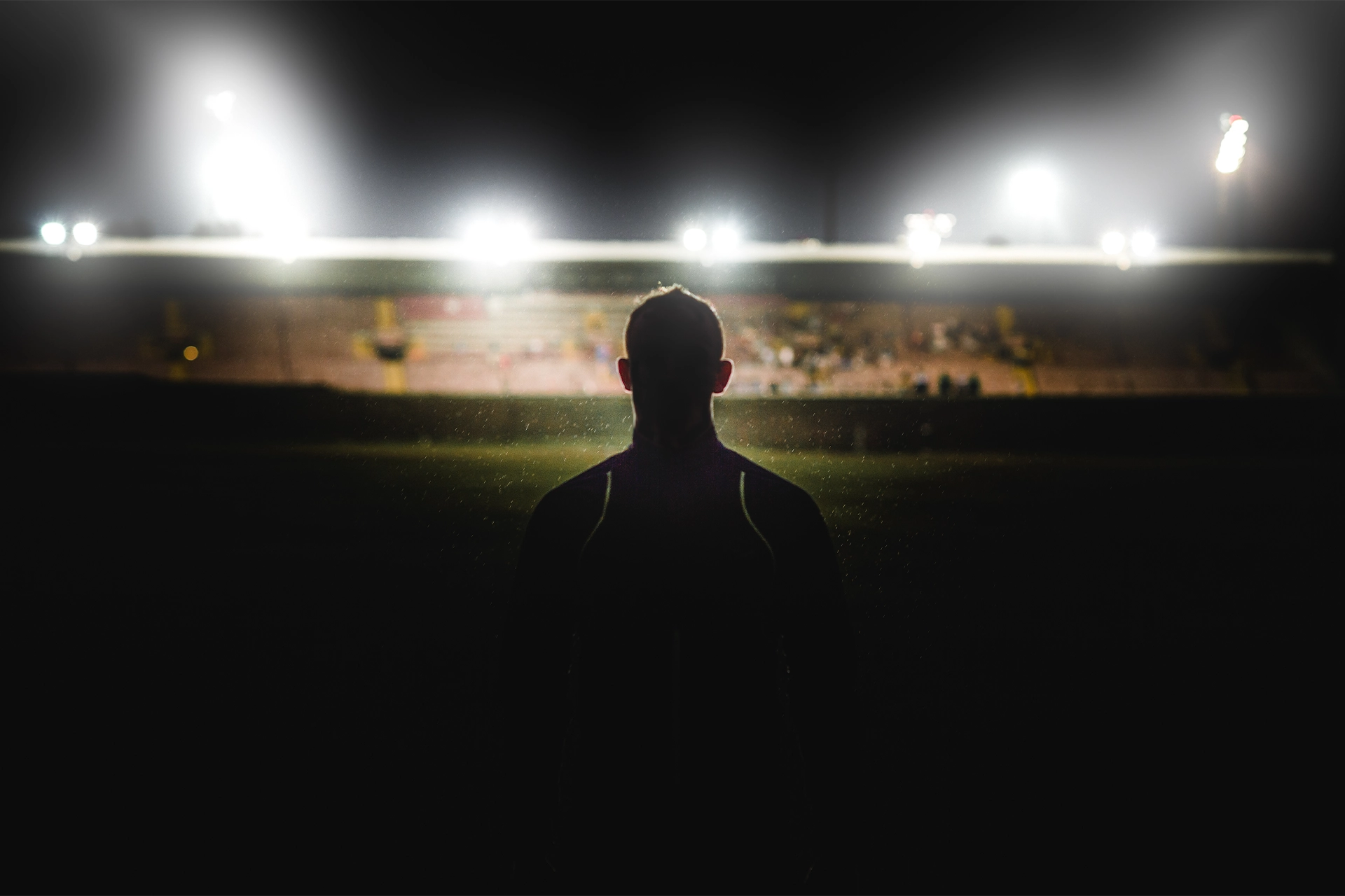 Athlete backlit in a dark stadium