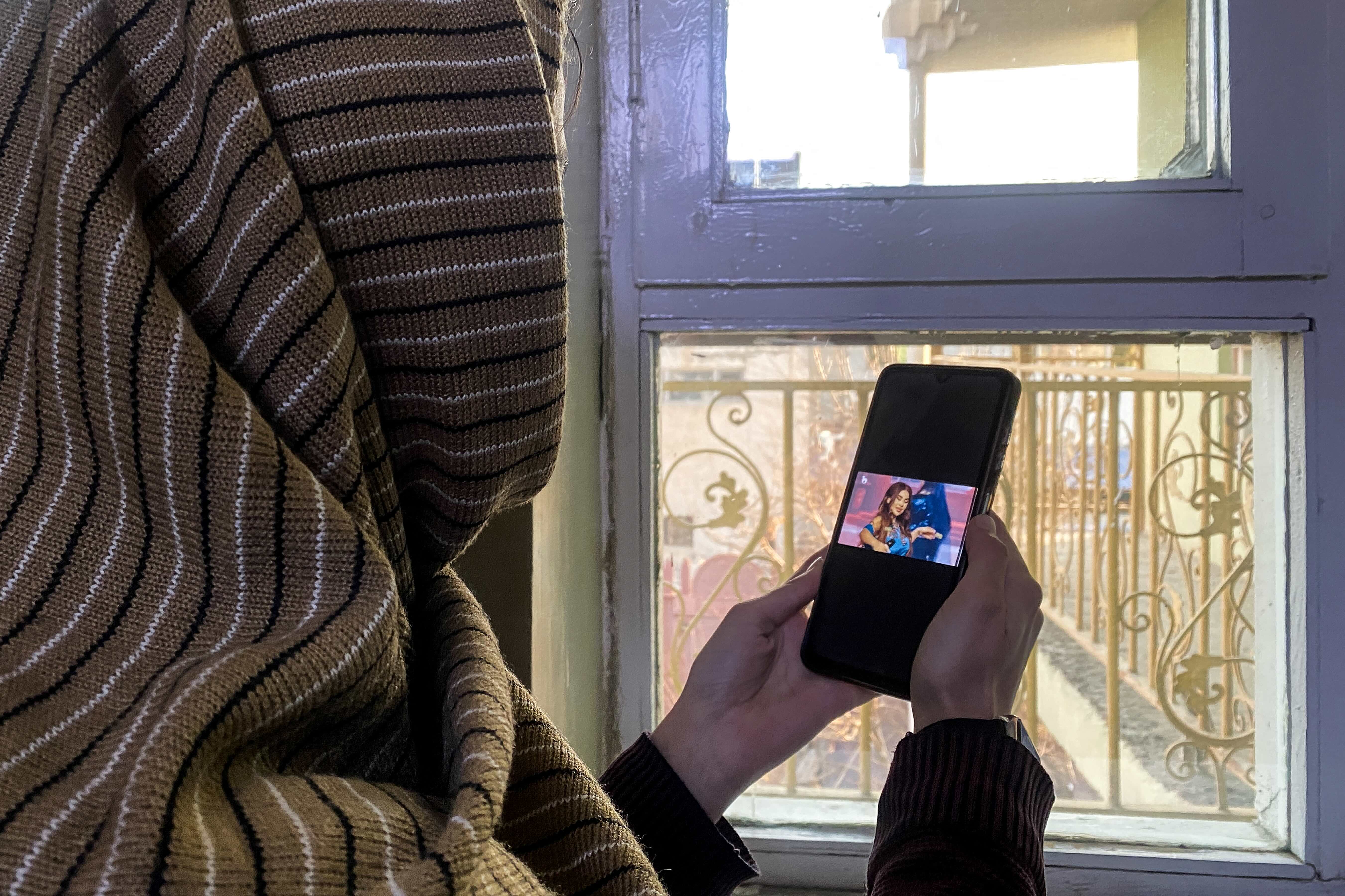 A woman in Afghanistan listens to Aryana Sayeed before the internet blackout