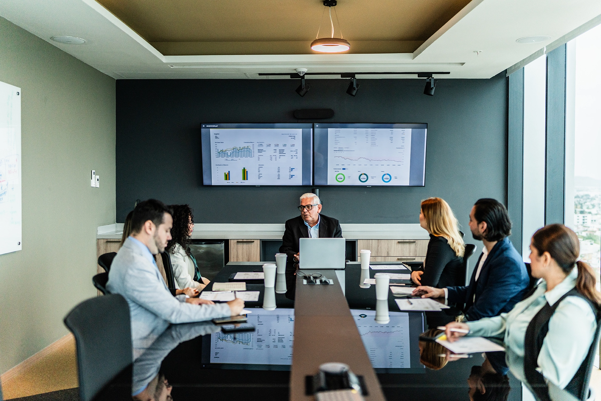 Group of people sitting around a boardroom table having a business meeting