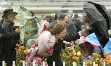 VRacegoers in wind Melbourne Cup