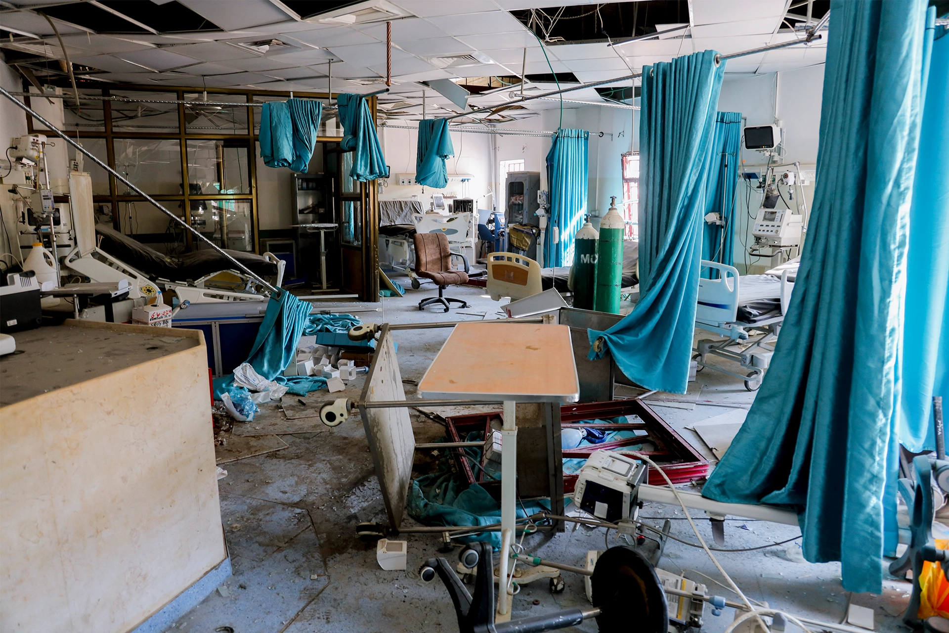 Abandoned hospital wing in Gaza, furniture upturned and roof tiles falling down