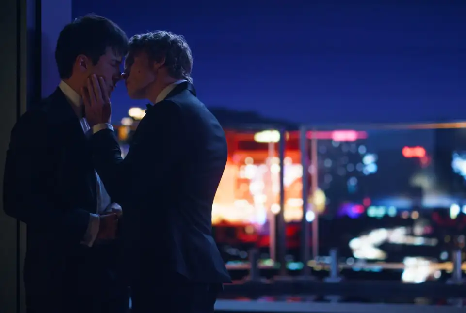 The two main characters of Heated Rivalry in an embrace on a rooftop
