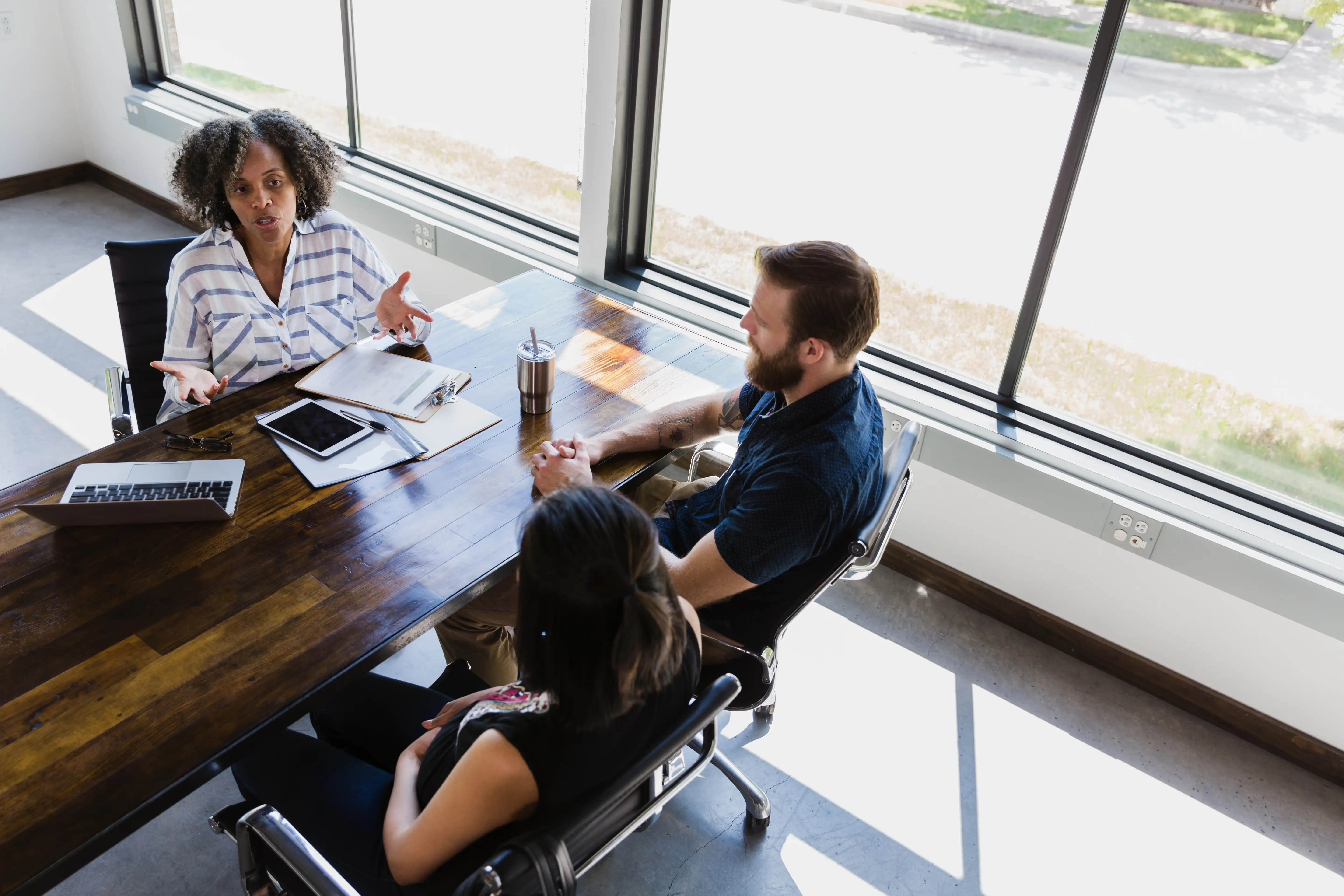 Two people in discussion with a counsellor or lender in an office environment