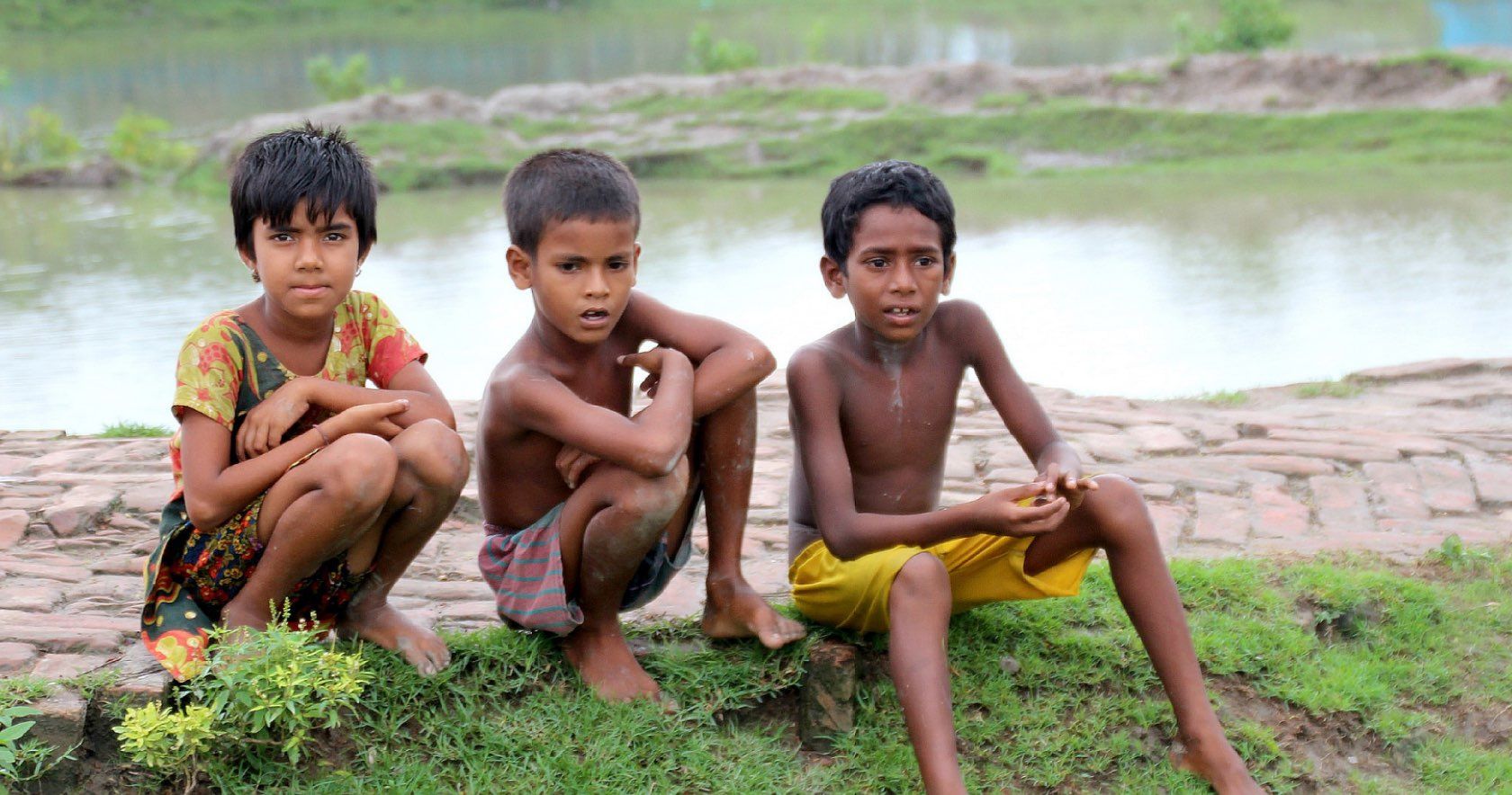 Children sitting on grass.