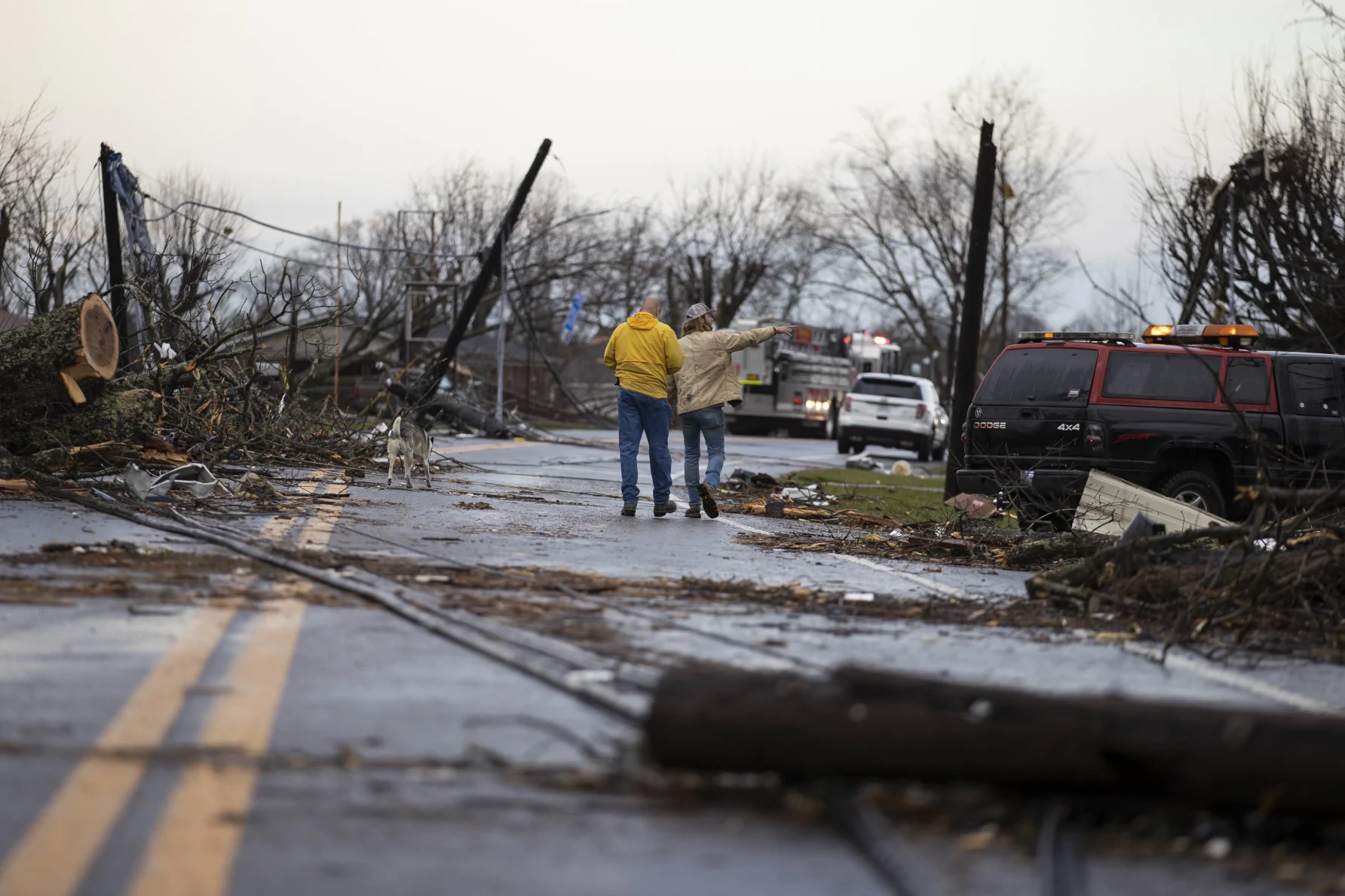 A couple walking down a road after a tornado