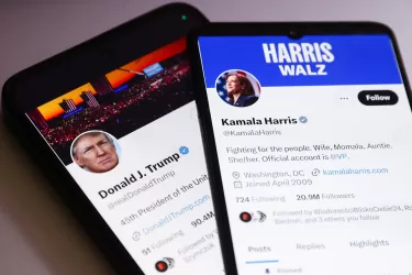 Two iPhones showing social media platform X feeds of Donald Trump and Kamala Harris