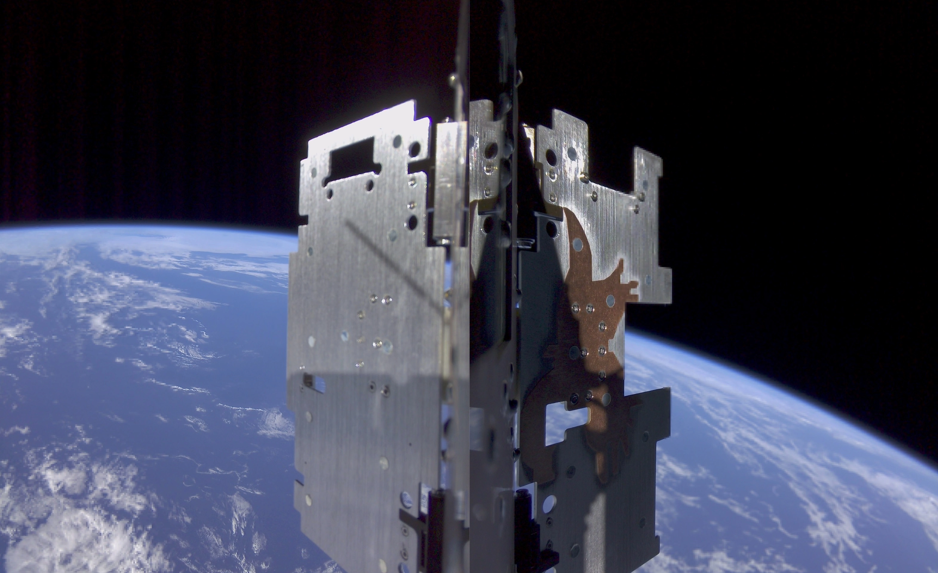 A metallic instrument in space, looking towards Earth