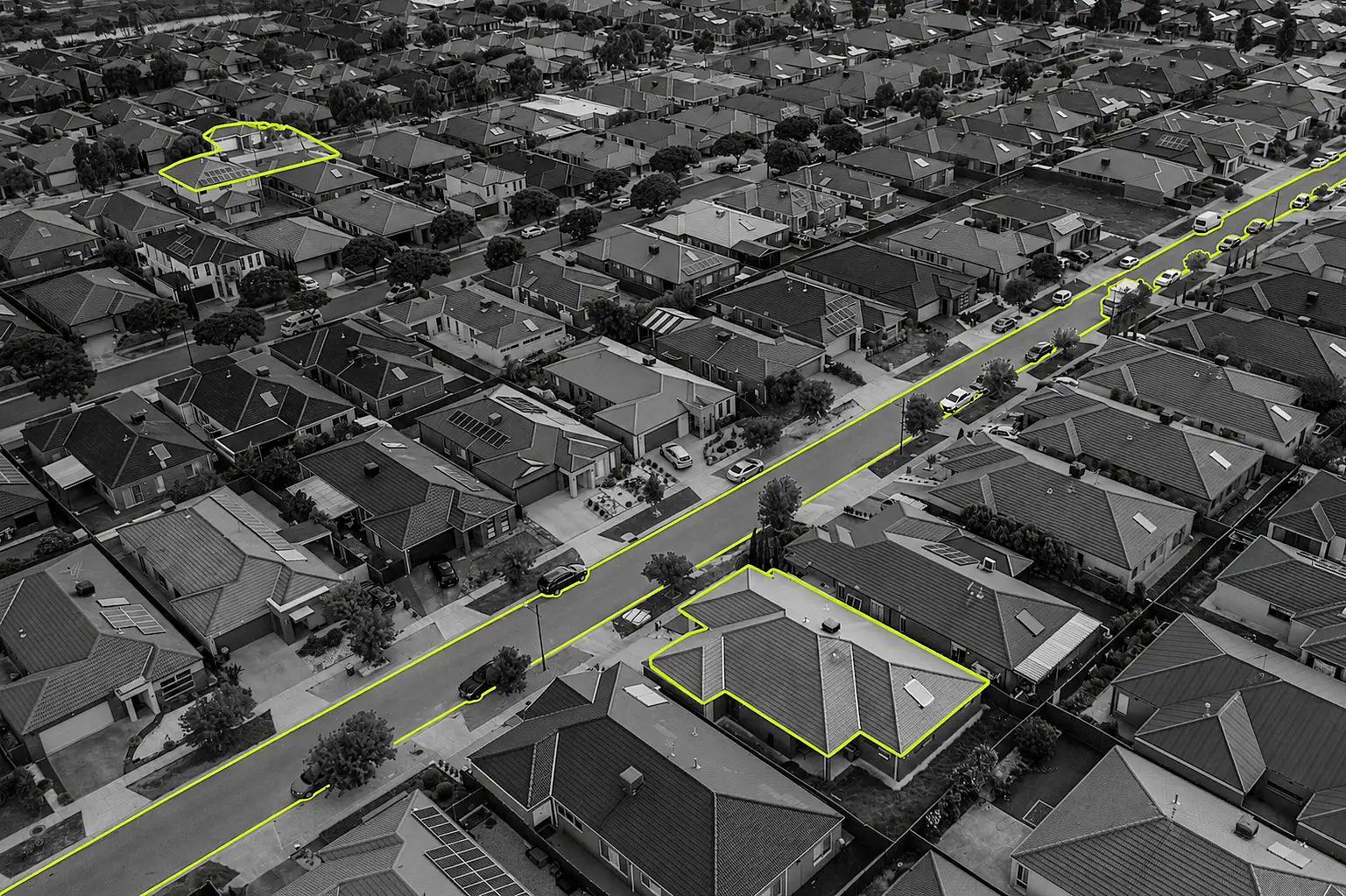A black-and-white photo of Melbourne's new outer suburbs with elements picked out in lime green