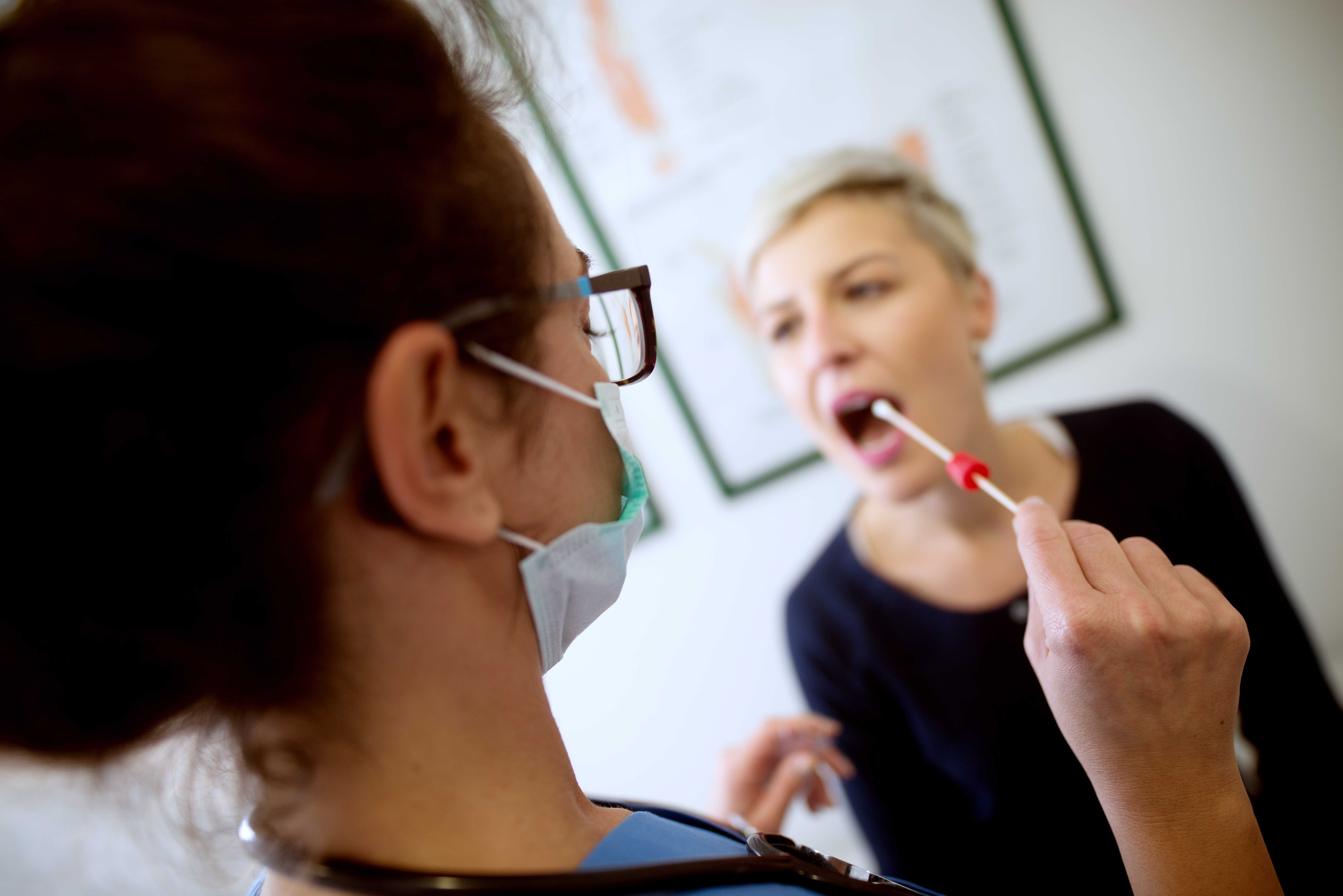 A doctor swabs a patient's cheek for genetic testing 