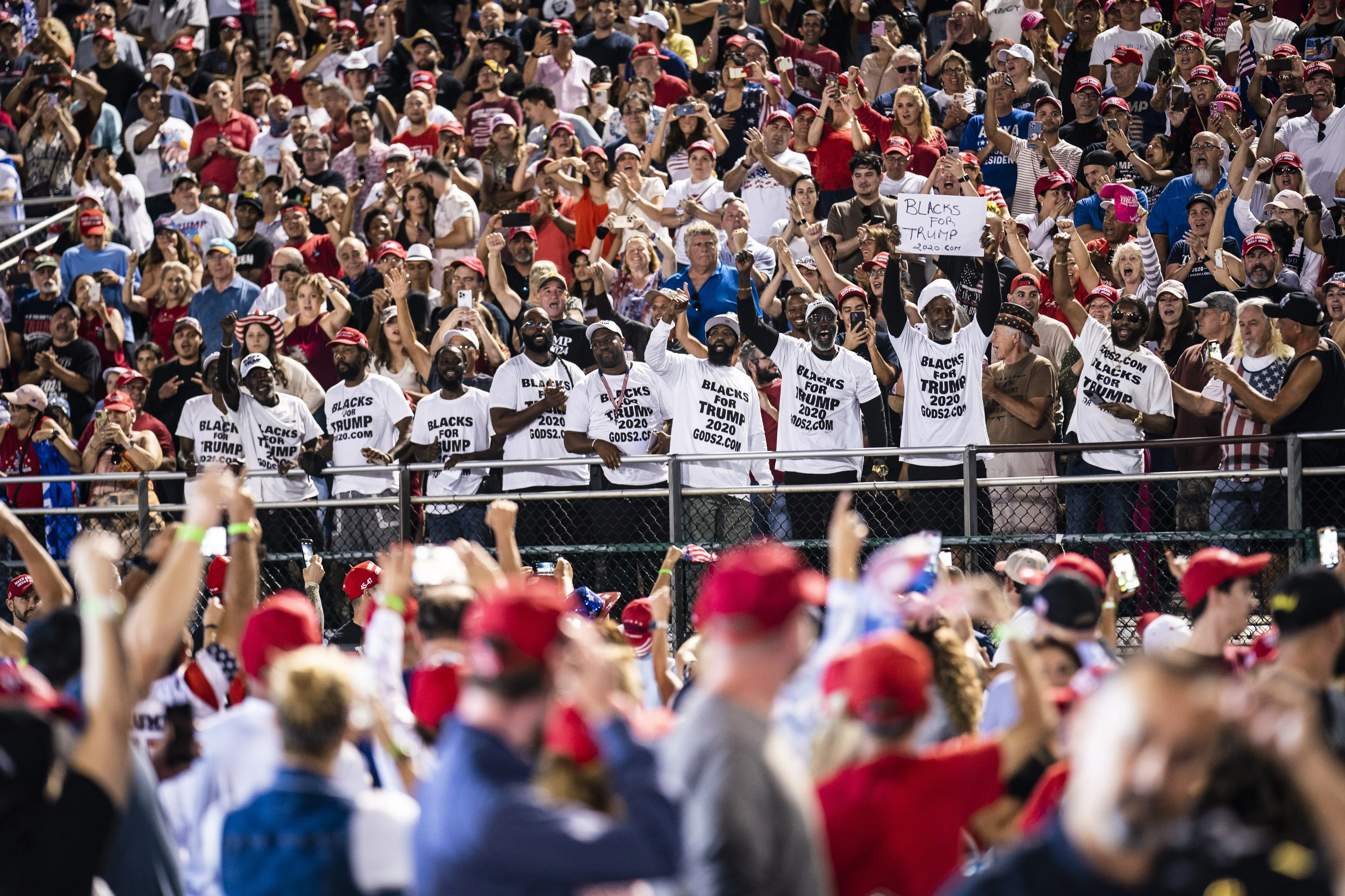 A group known as "Blacks for Trump" cheer as former President Donald Trump begins speaking at a campaign rally