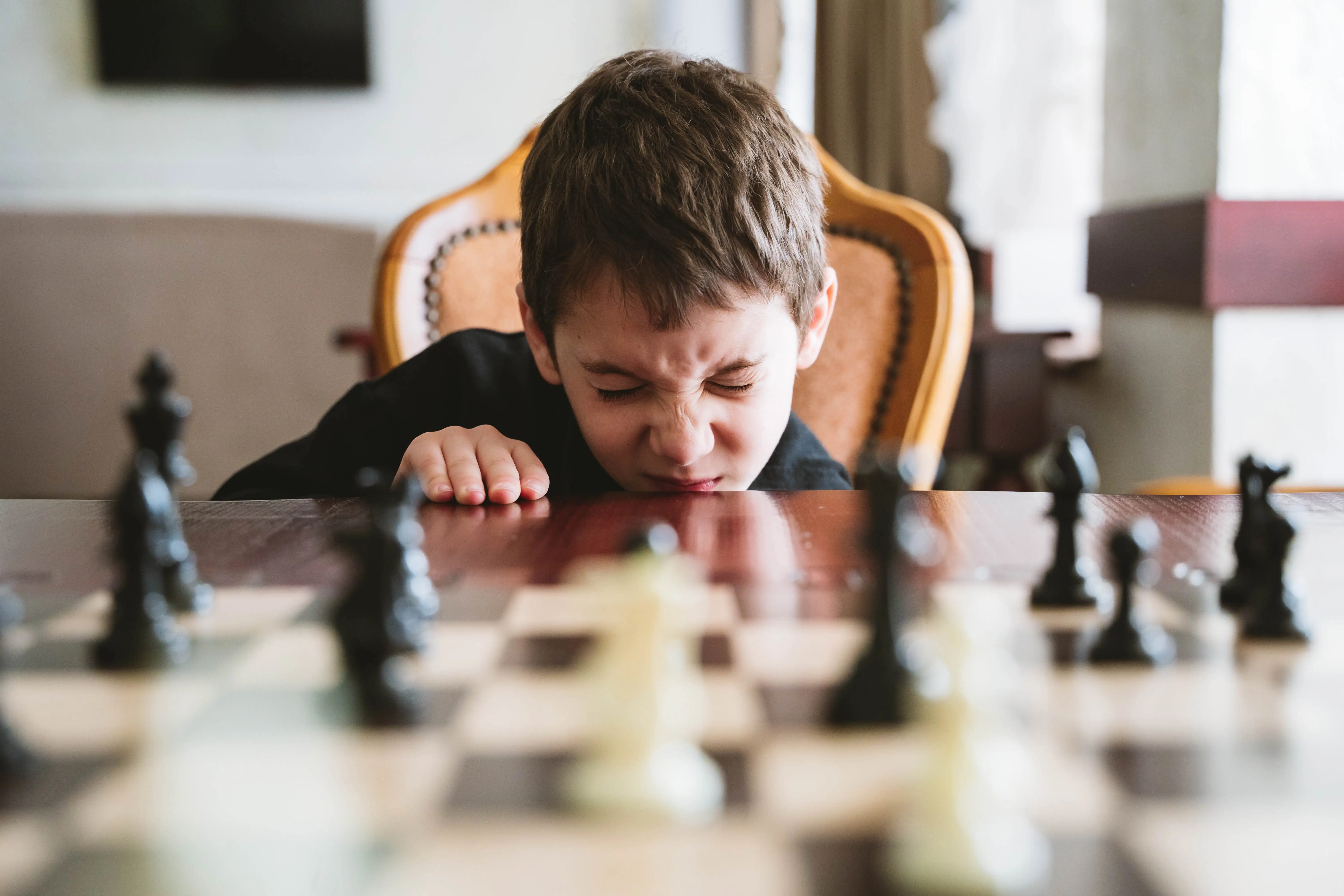 A boy squints as a chess board