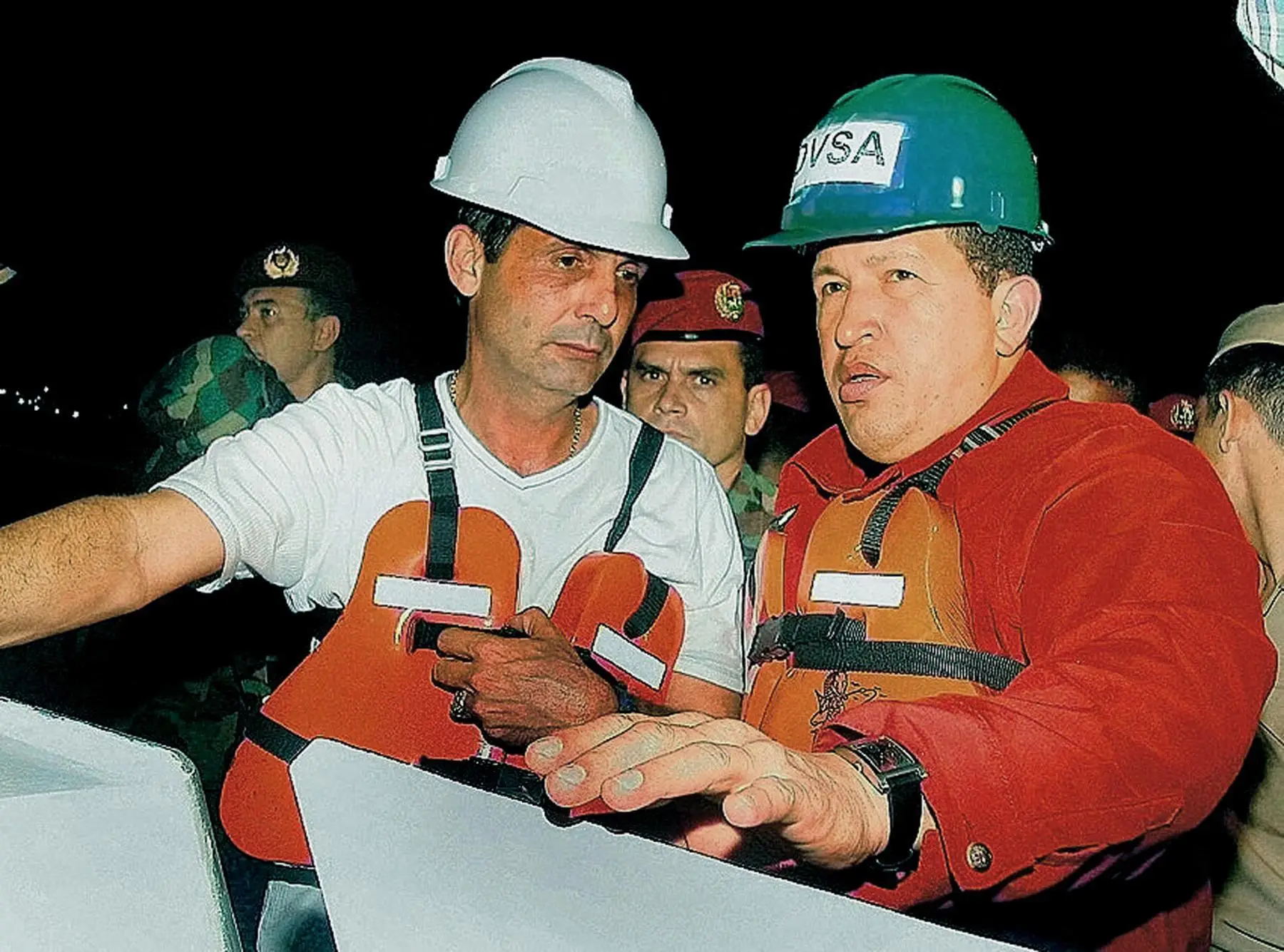 Venezuelan President Hugo Chavez speaks to an oil tanker crew member in 2002