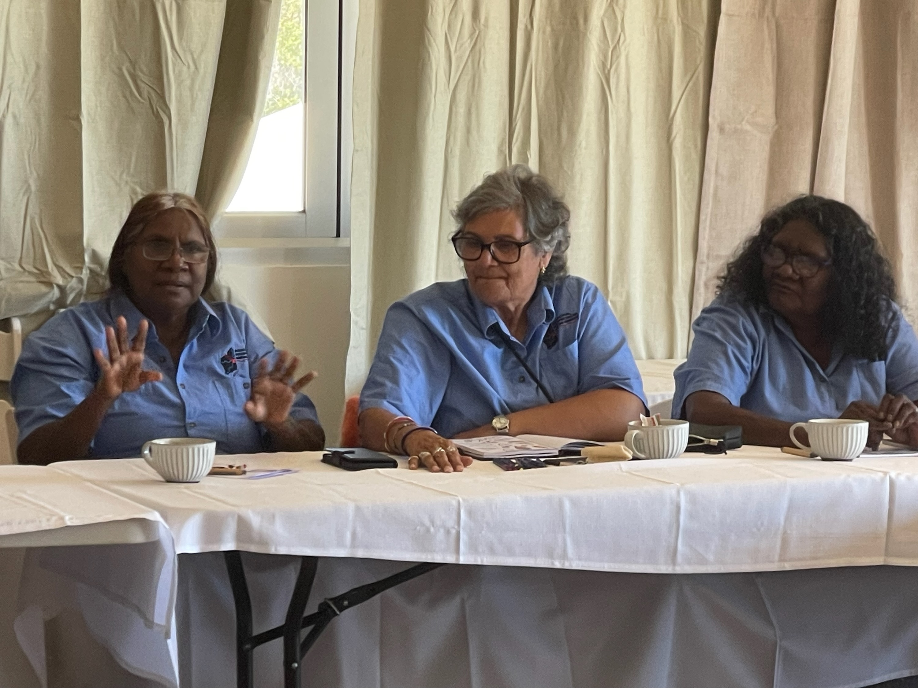 three First Nations interpreters sitting at a desk during a workshop