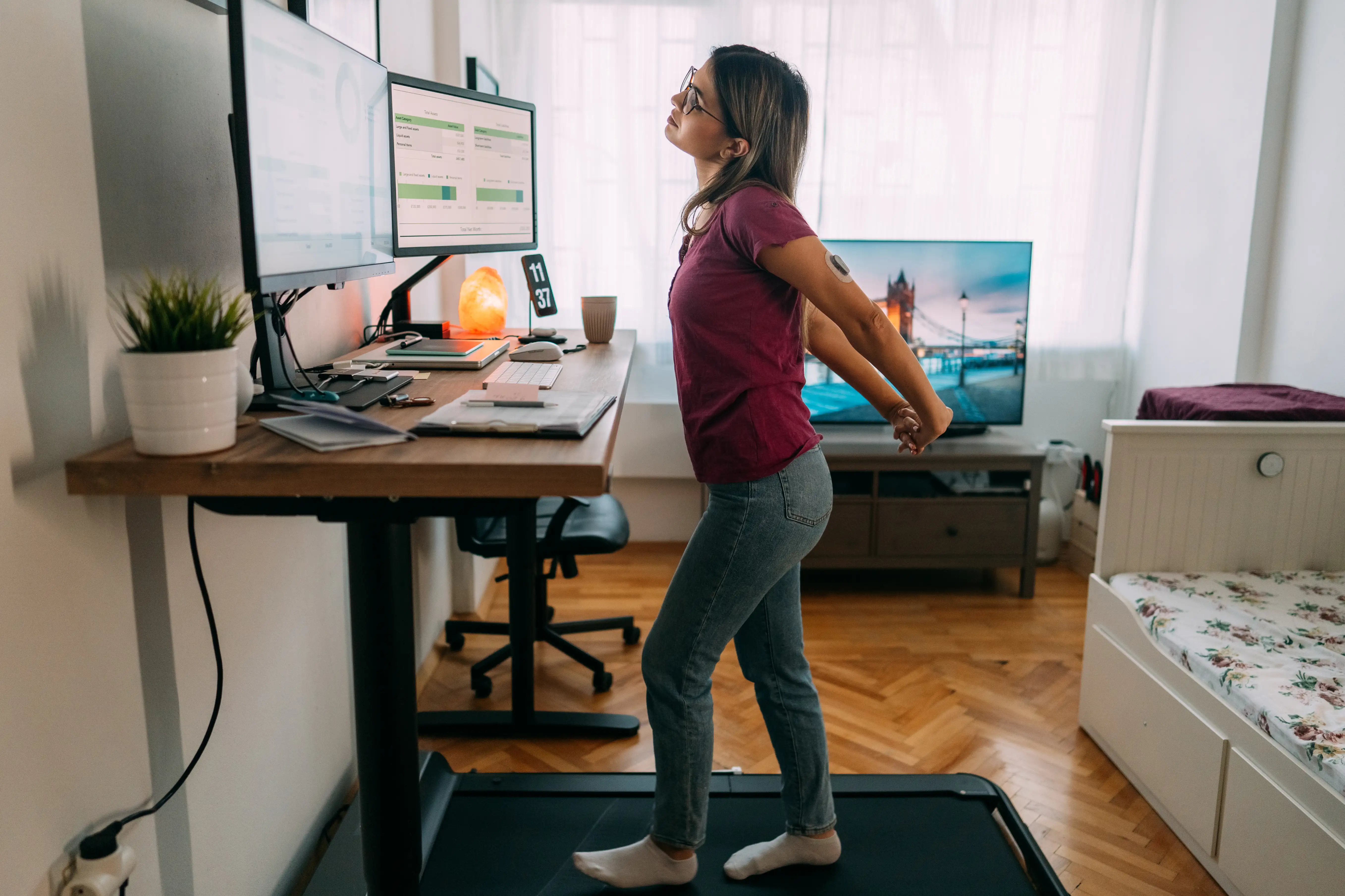 Woman at home office stretching out her back