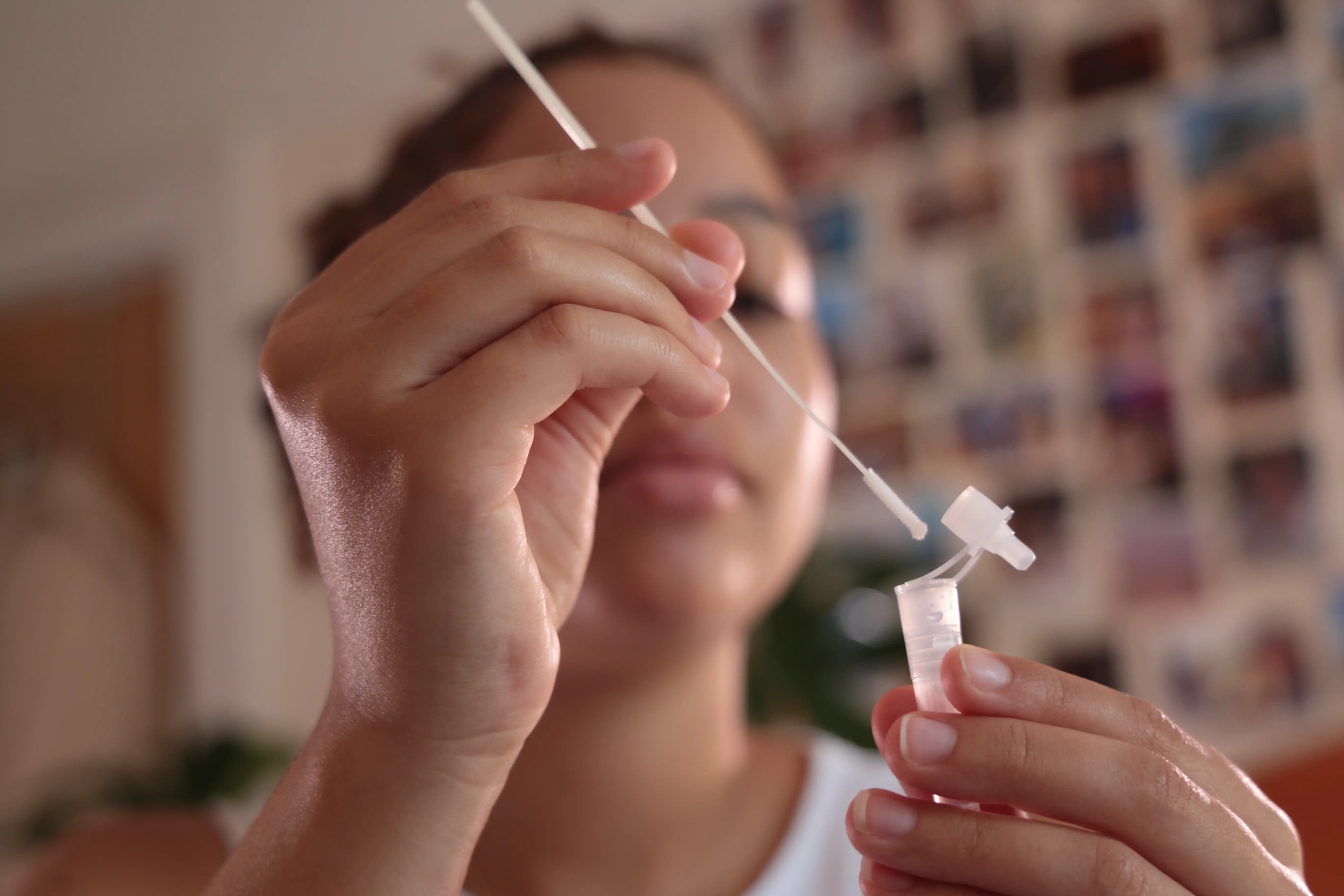 A young woman packing up a mouth swab of DNA