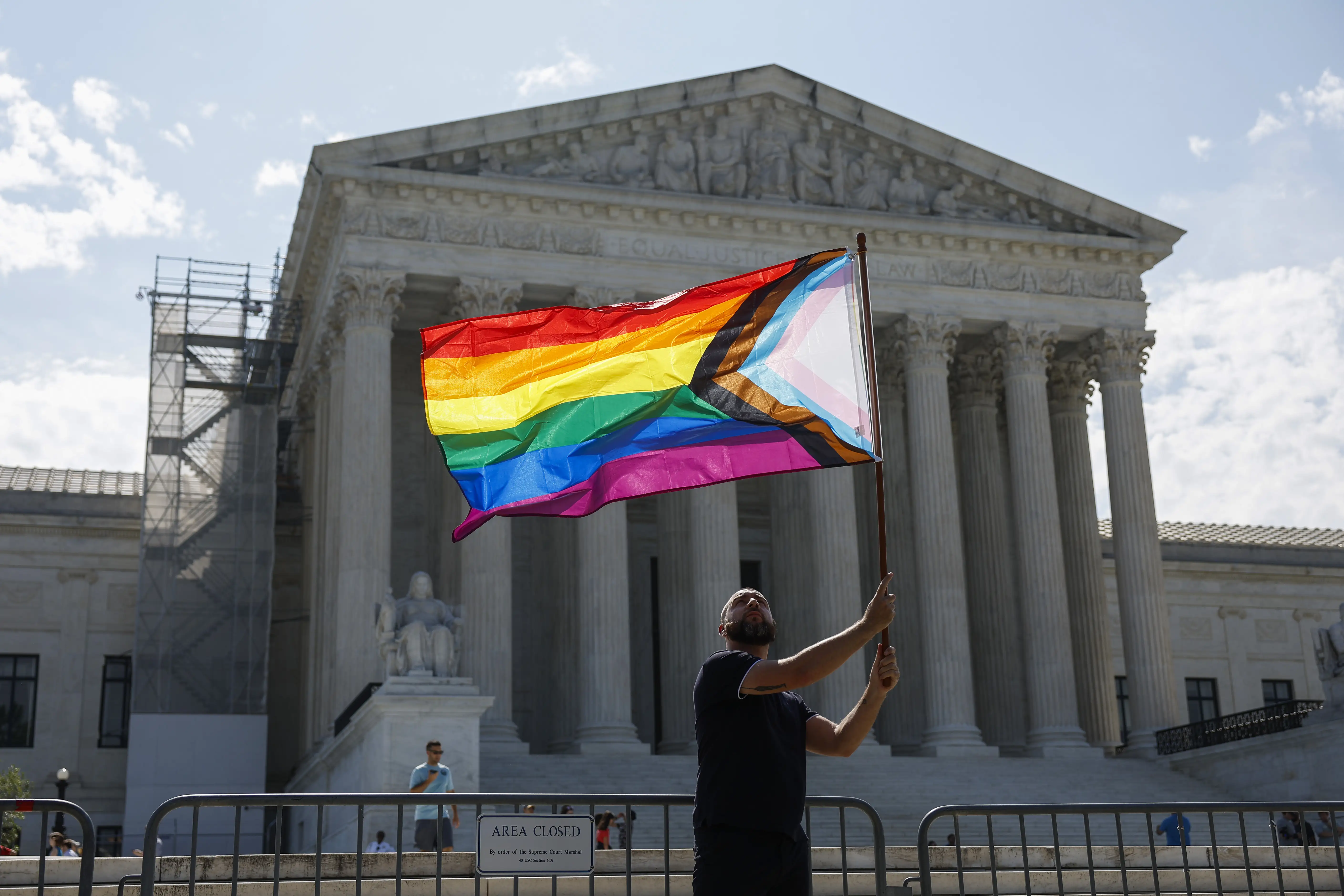 A demonstrator waves a LGBTQIA pride flag in front of the U.S. Supreme Court Building