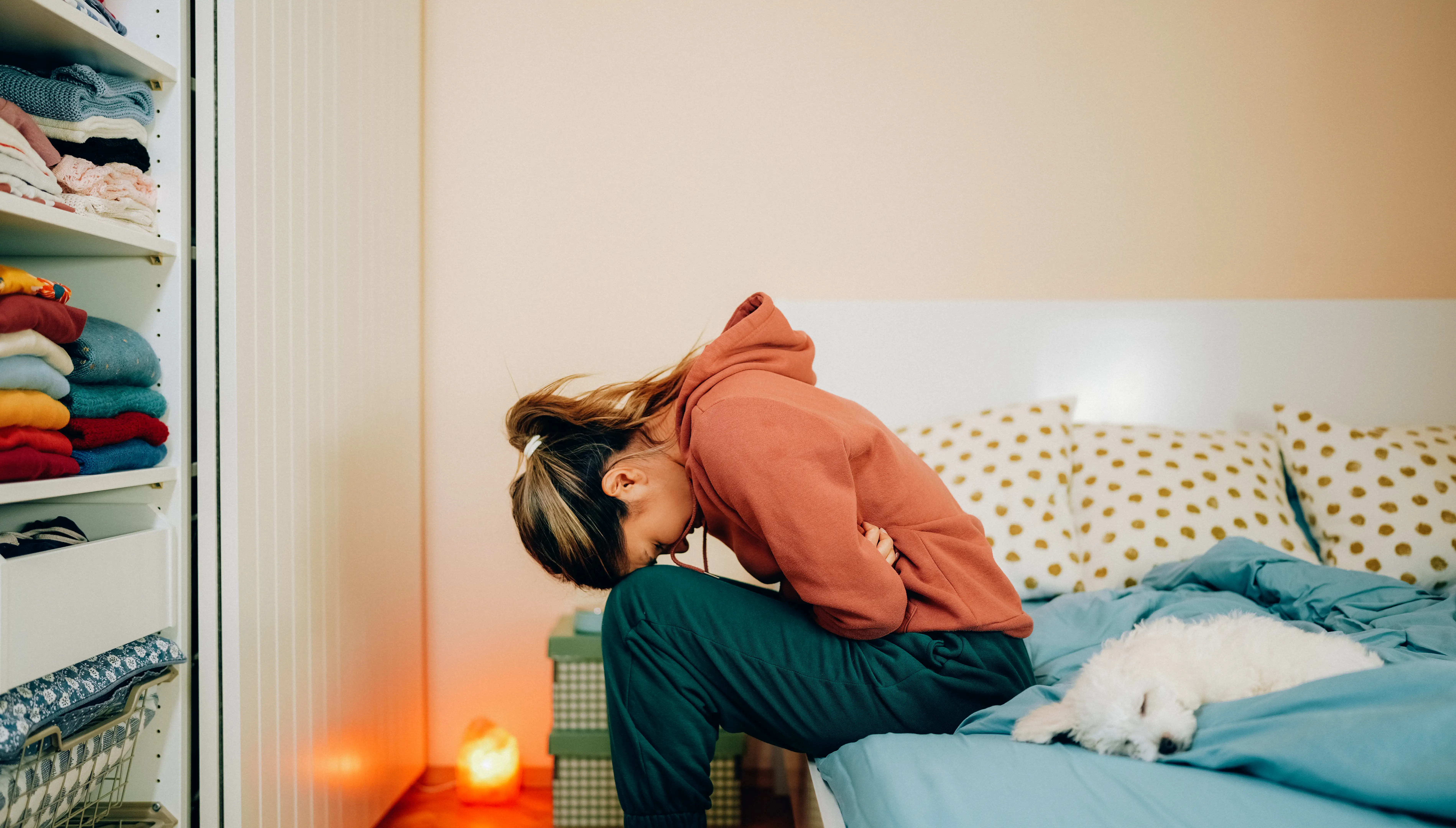 A young woman clutching stomach in discomfort