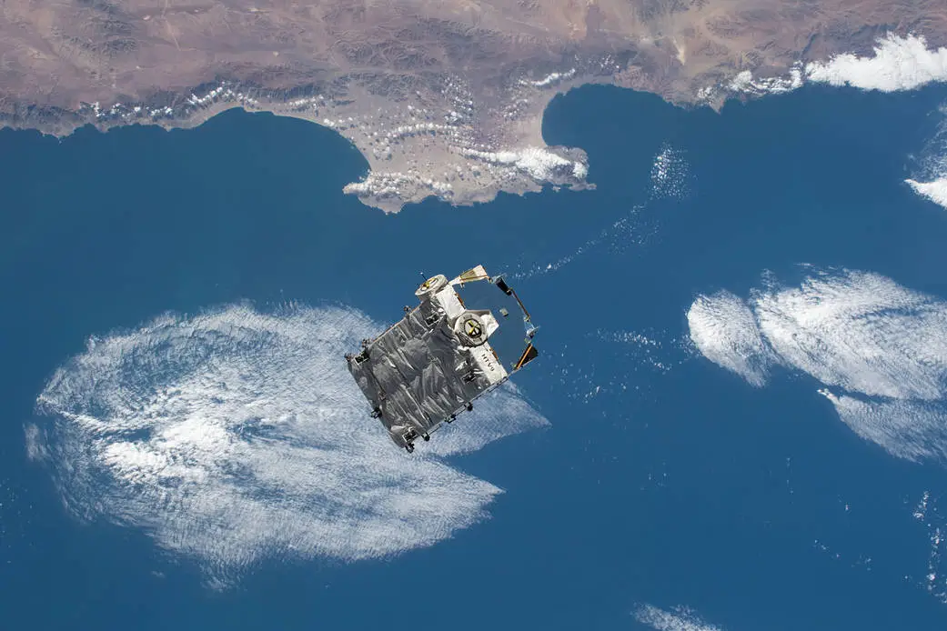 A cargo pallet containing used batteries that was jettisoned from the International Space Station (ISS) floats above Earth.