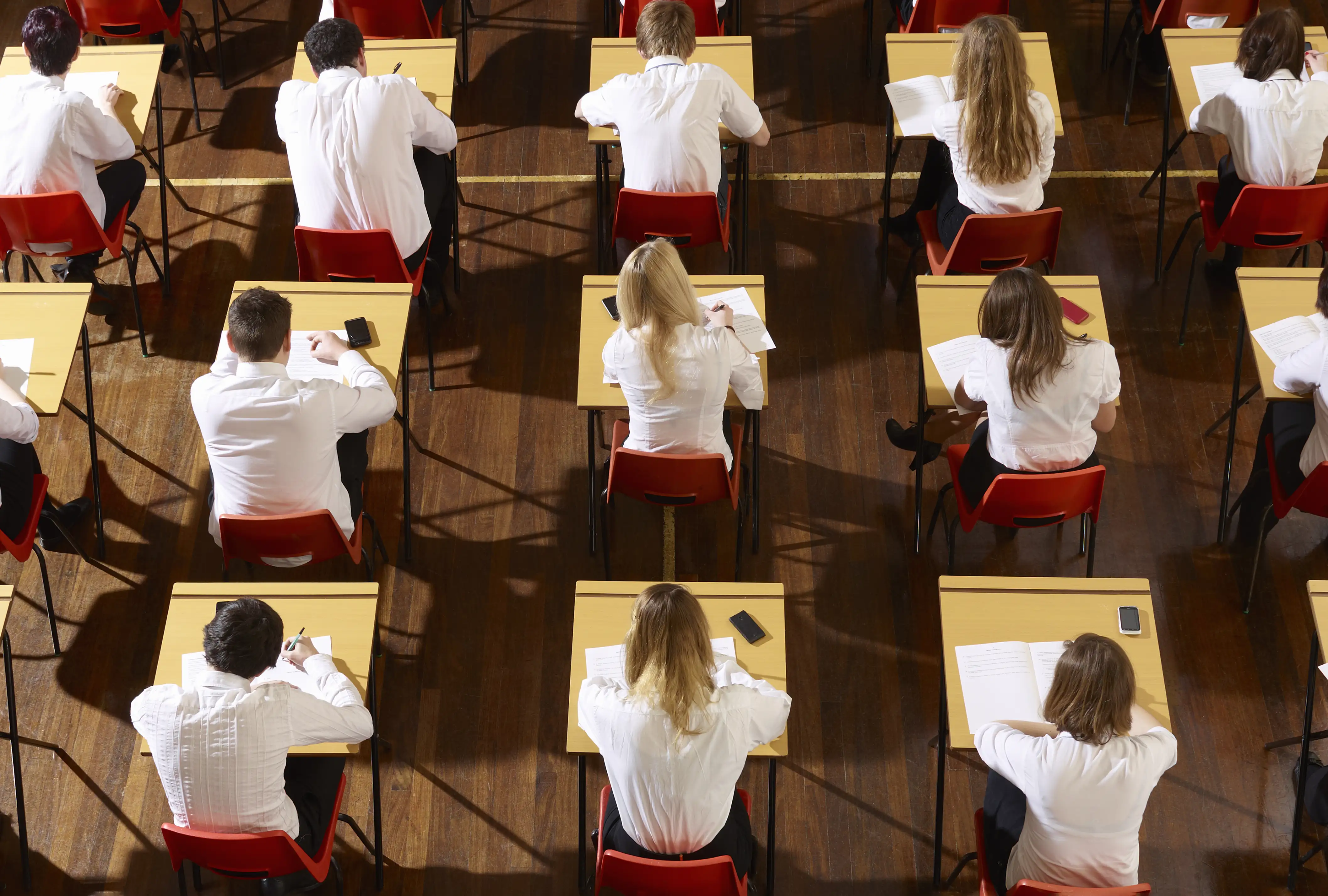Students taking exams in a hall shot from above
