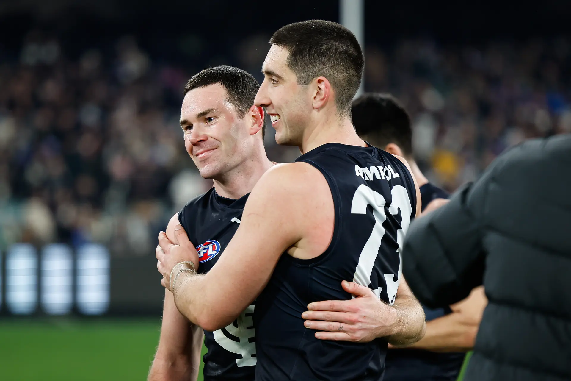 Two Carlton football club players embracing