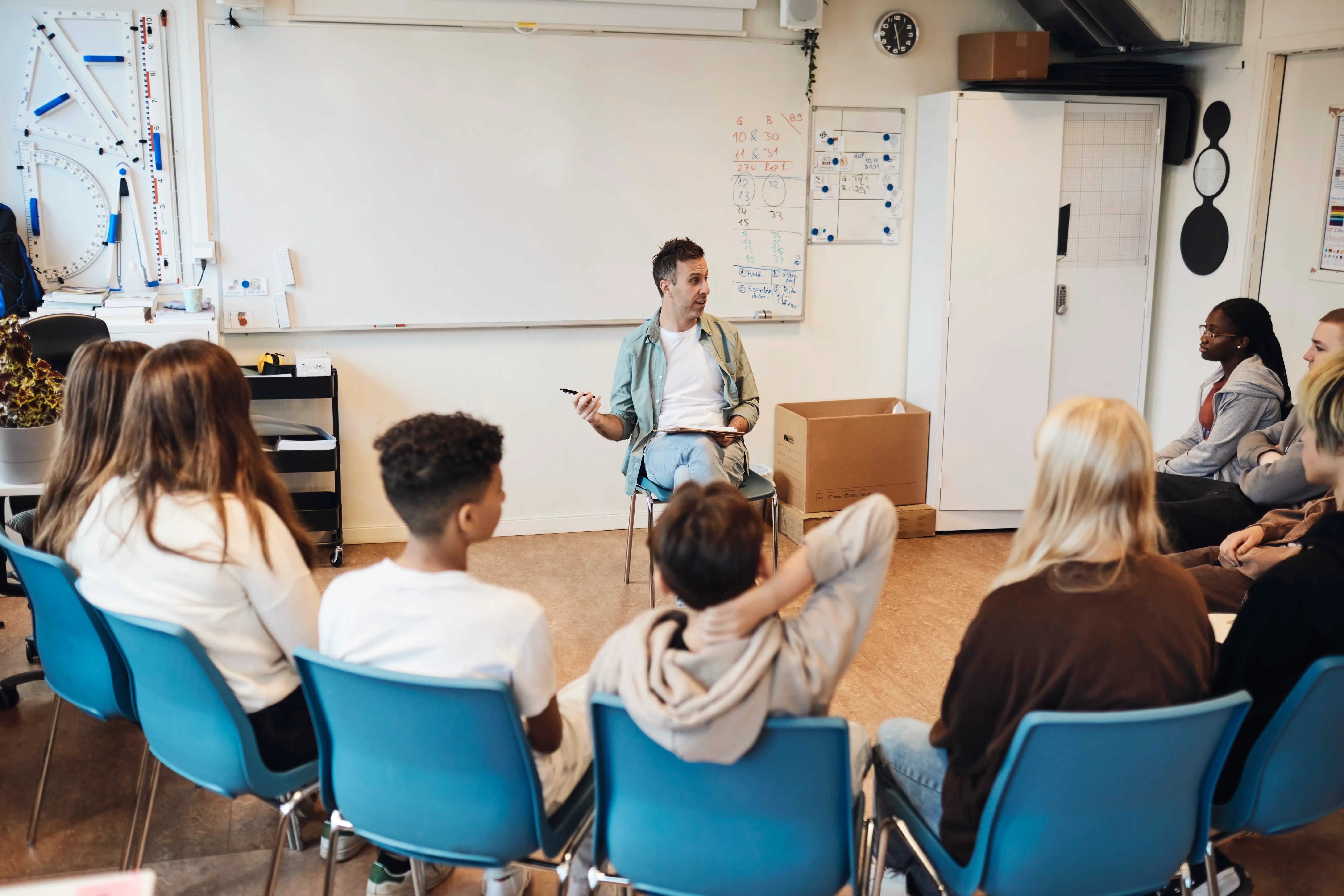 A mental health worker speaks to a group of children at school