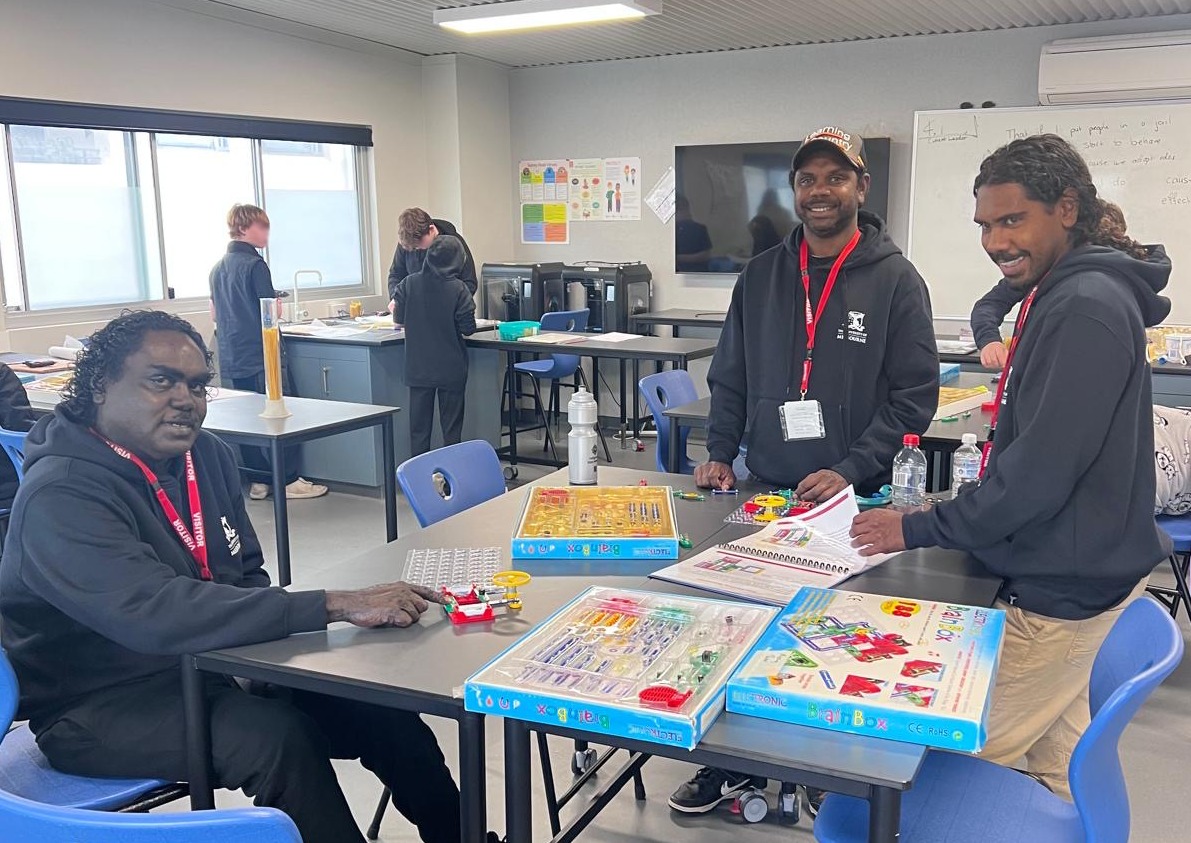 Three young male teachers in classroom