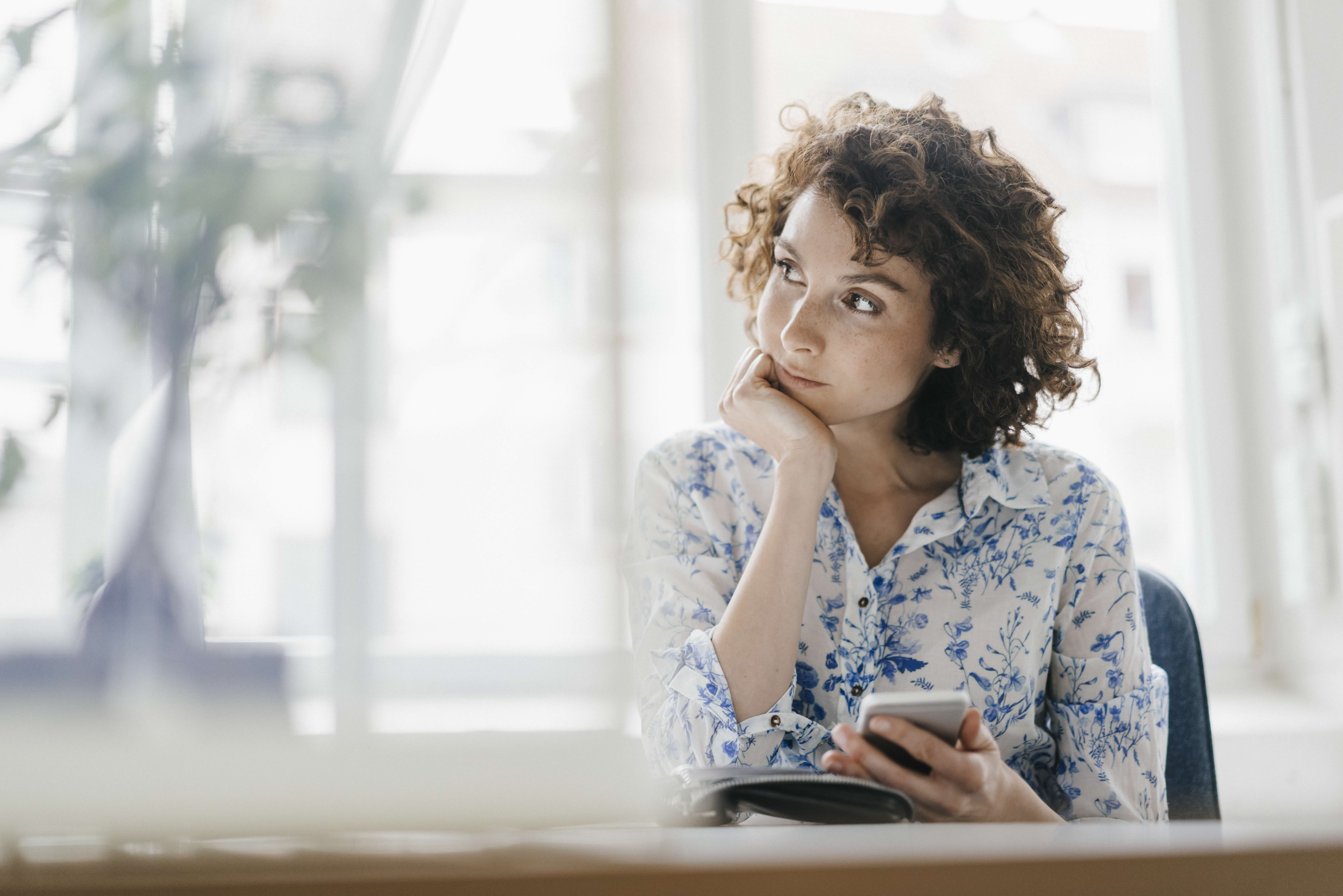 Woman thinking while on phone