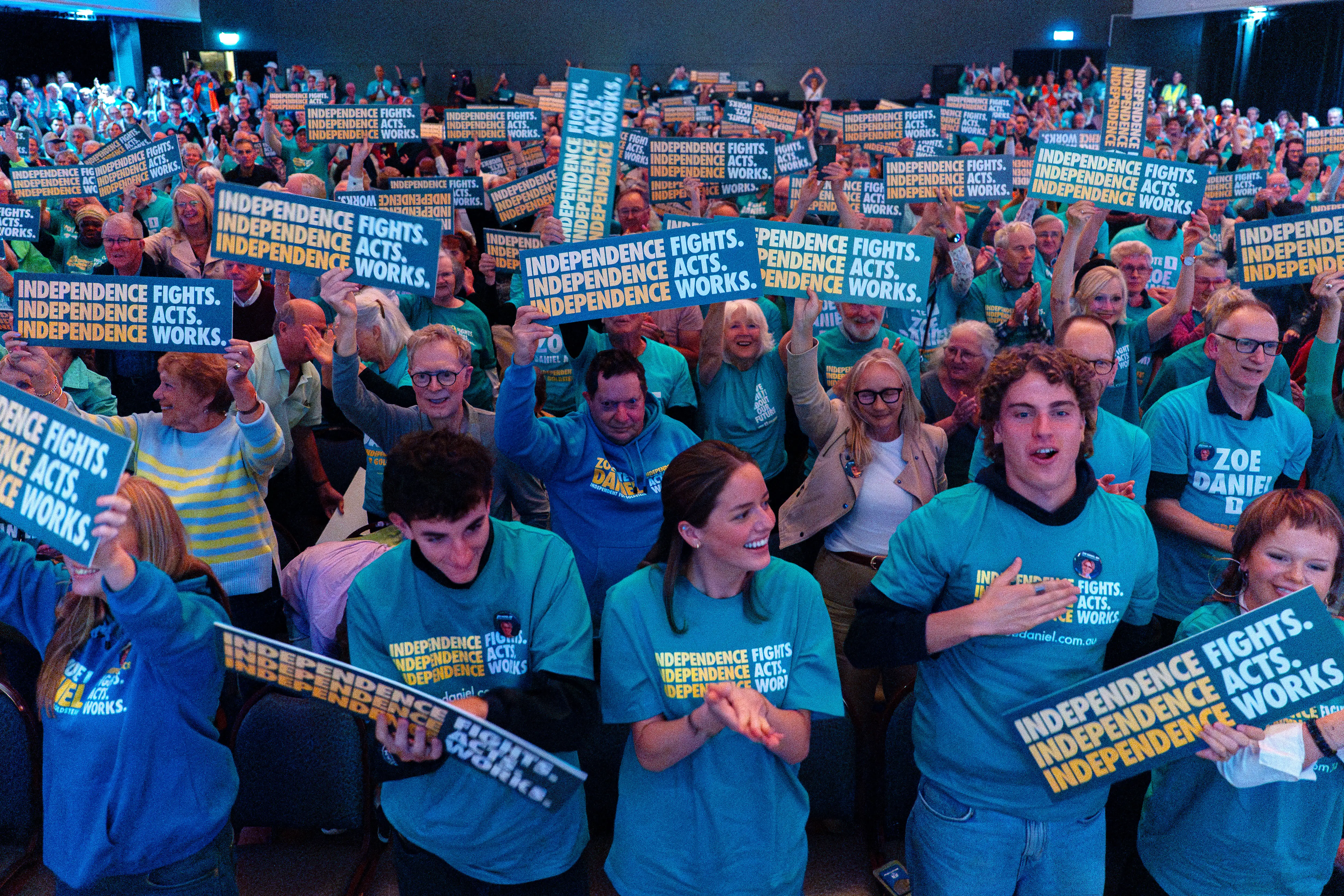 Teal supporters wearing green shirts holding signs saying ‘Independence fights, independence acts, independence works’