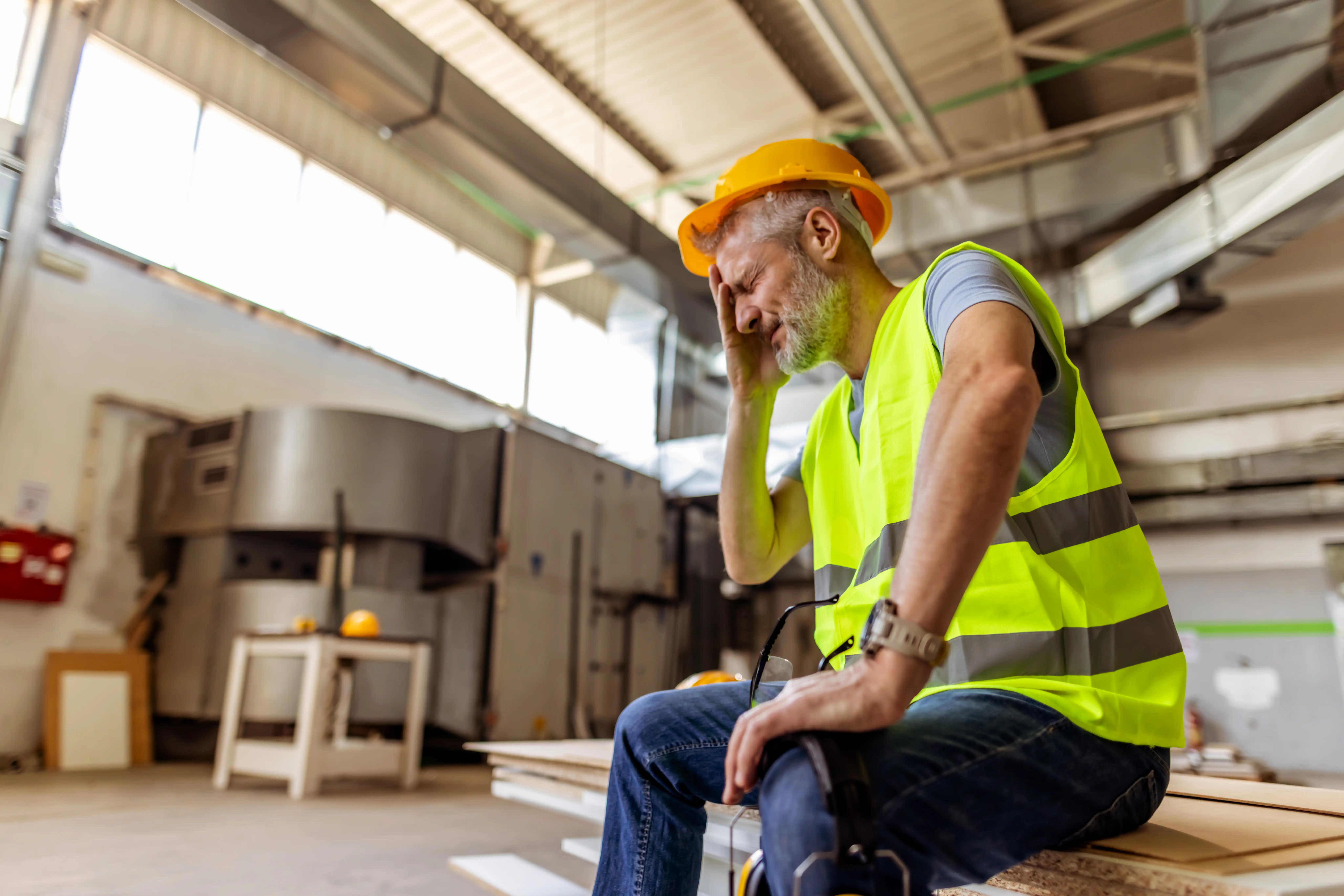 A man with stomach pain at work on a building site