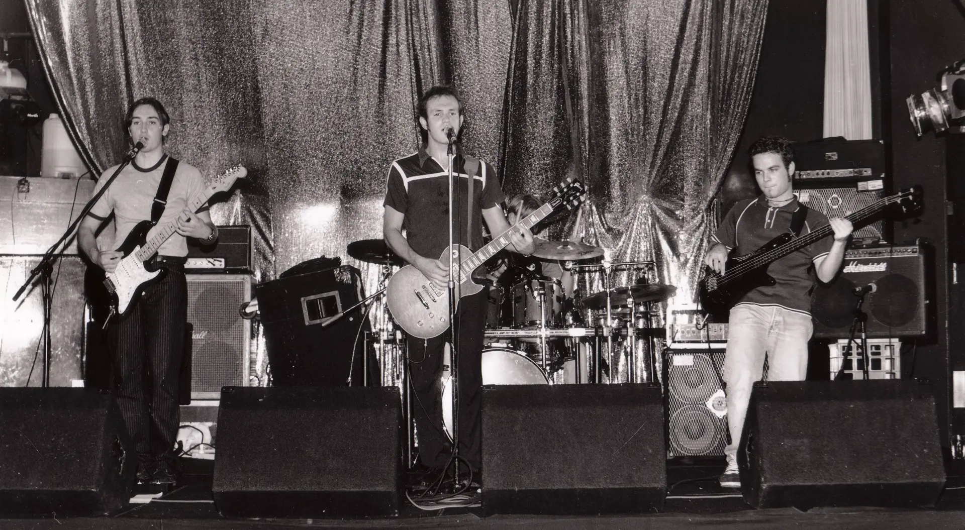 Photo from the 1990s of a rock band on a small stage