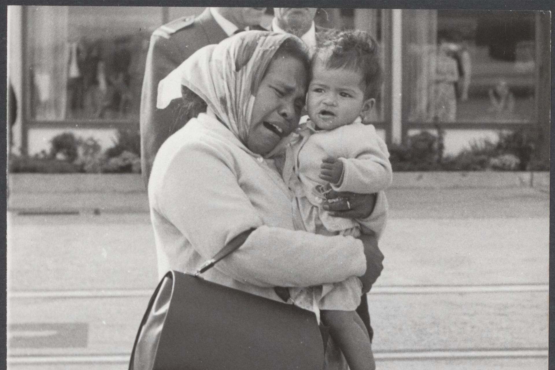 Old photo of a crying Indonesian woman holding a baby
