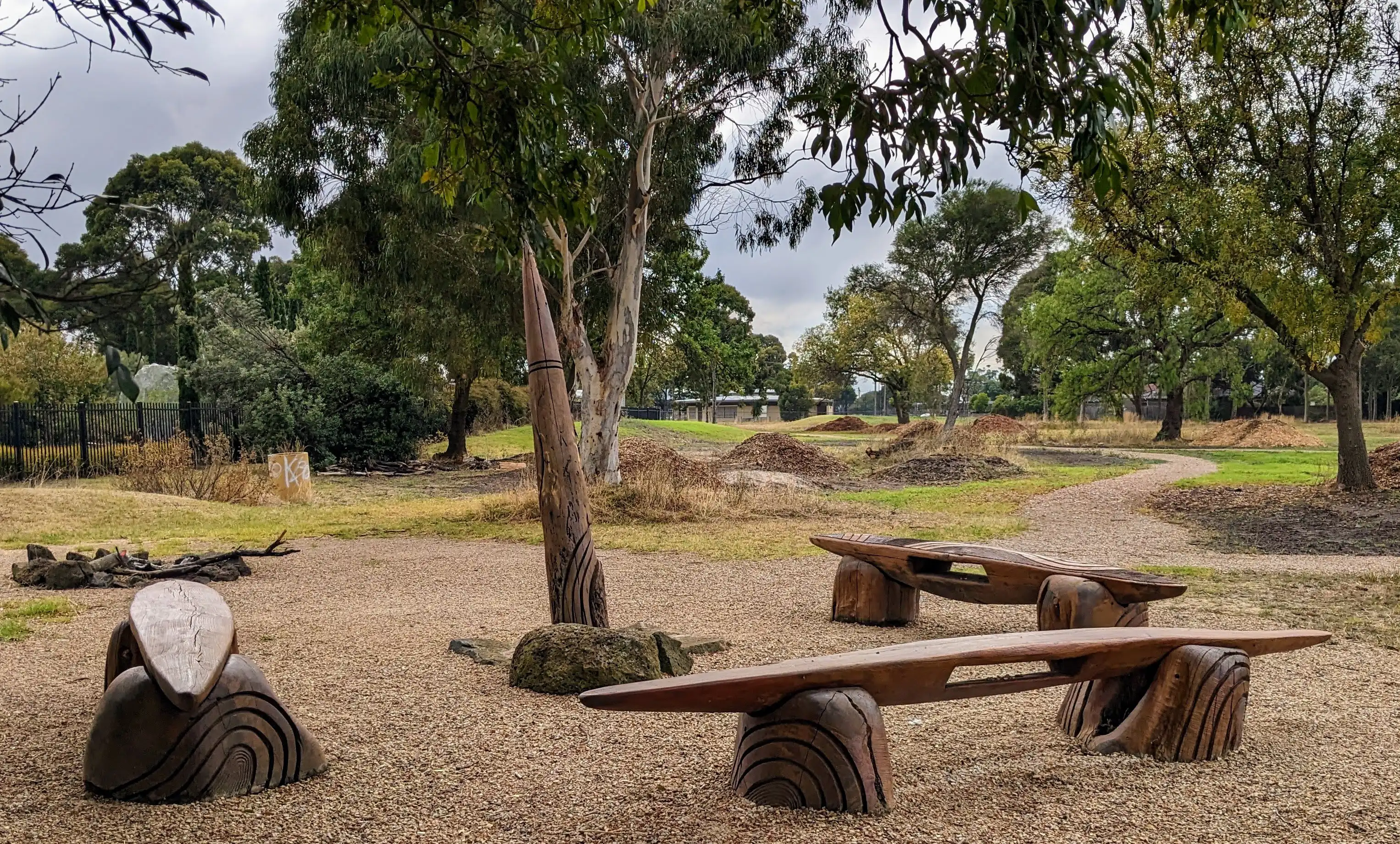 A ceremonial ground with firepit totem and benches in the shape of a shield