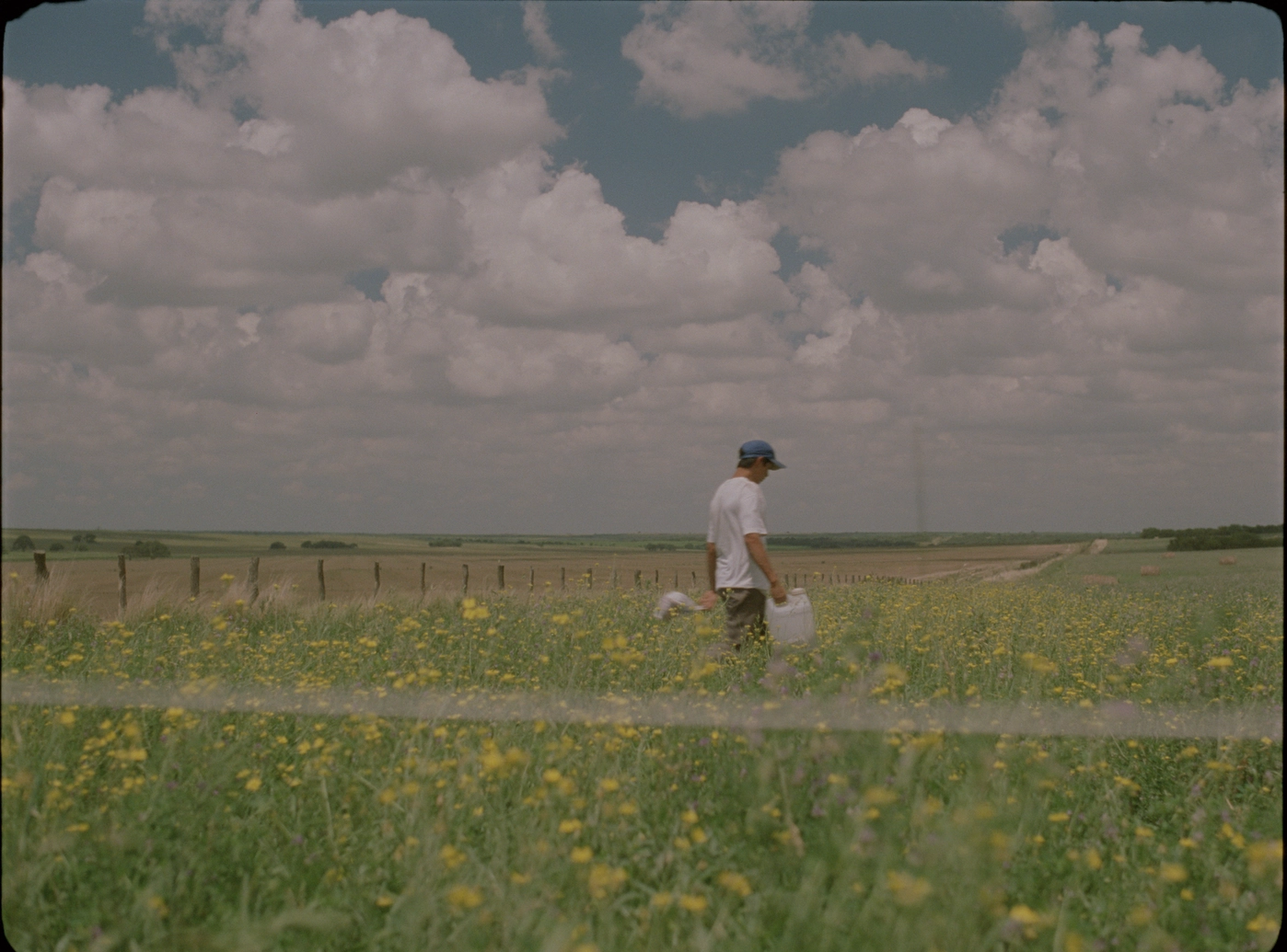 A film still of a man walking in a field