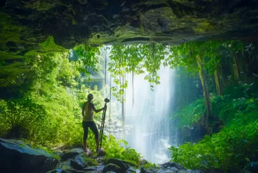 A young woman getting a waterfall shot in Dorrigal National Park