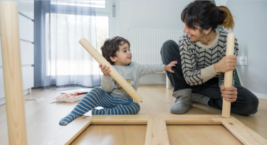Mother and toddler son assembling furniture