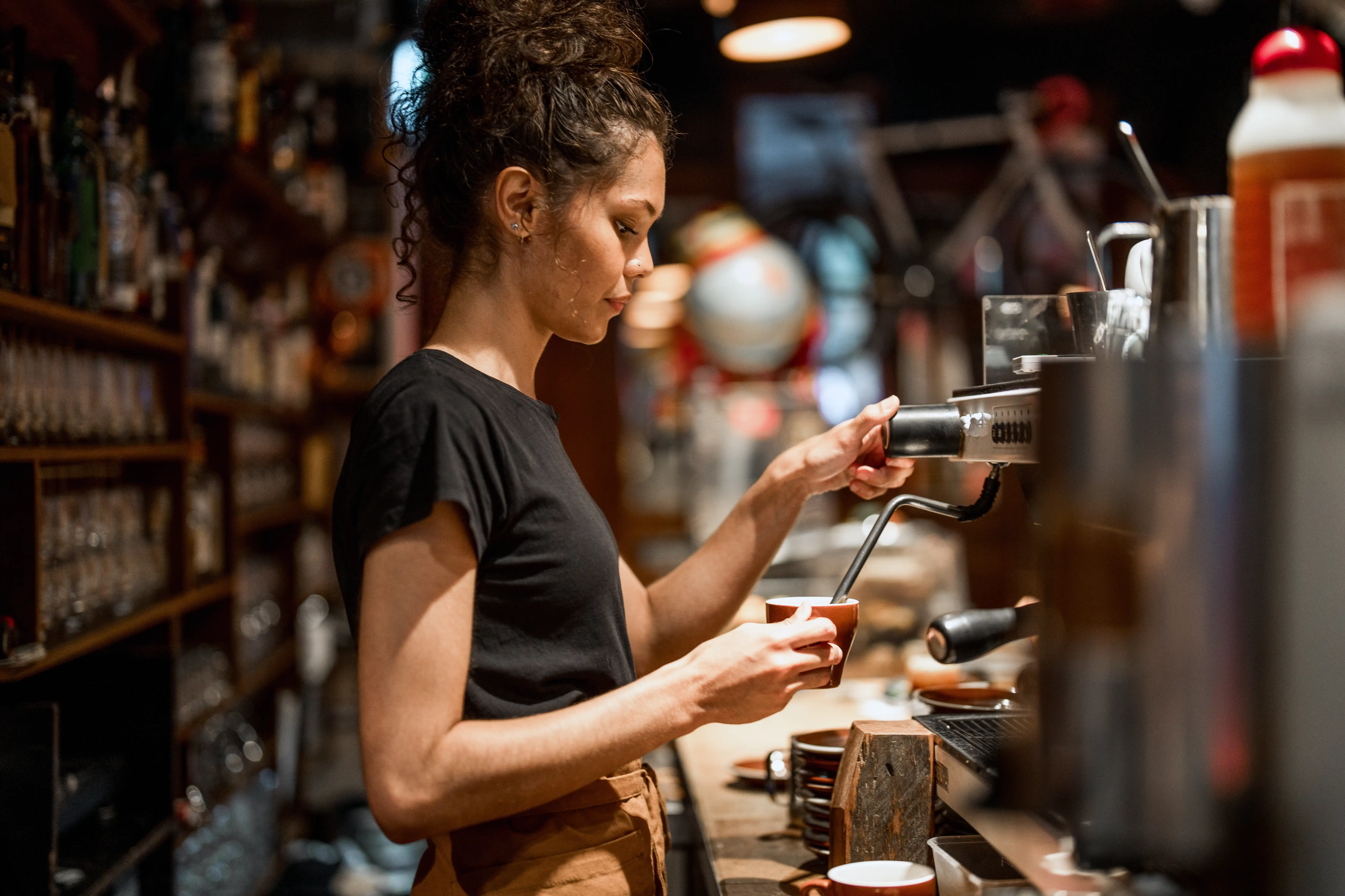 A barista making a coffee in a cafe