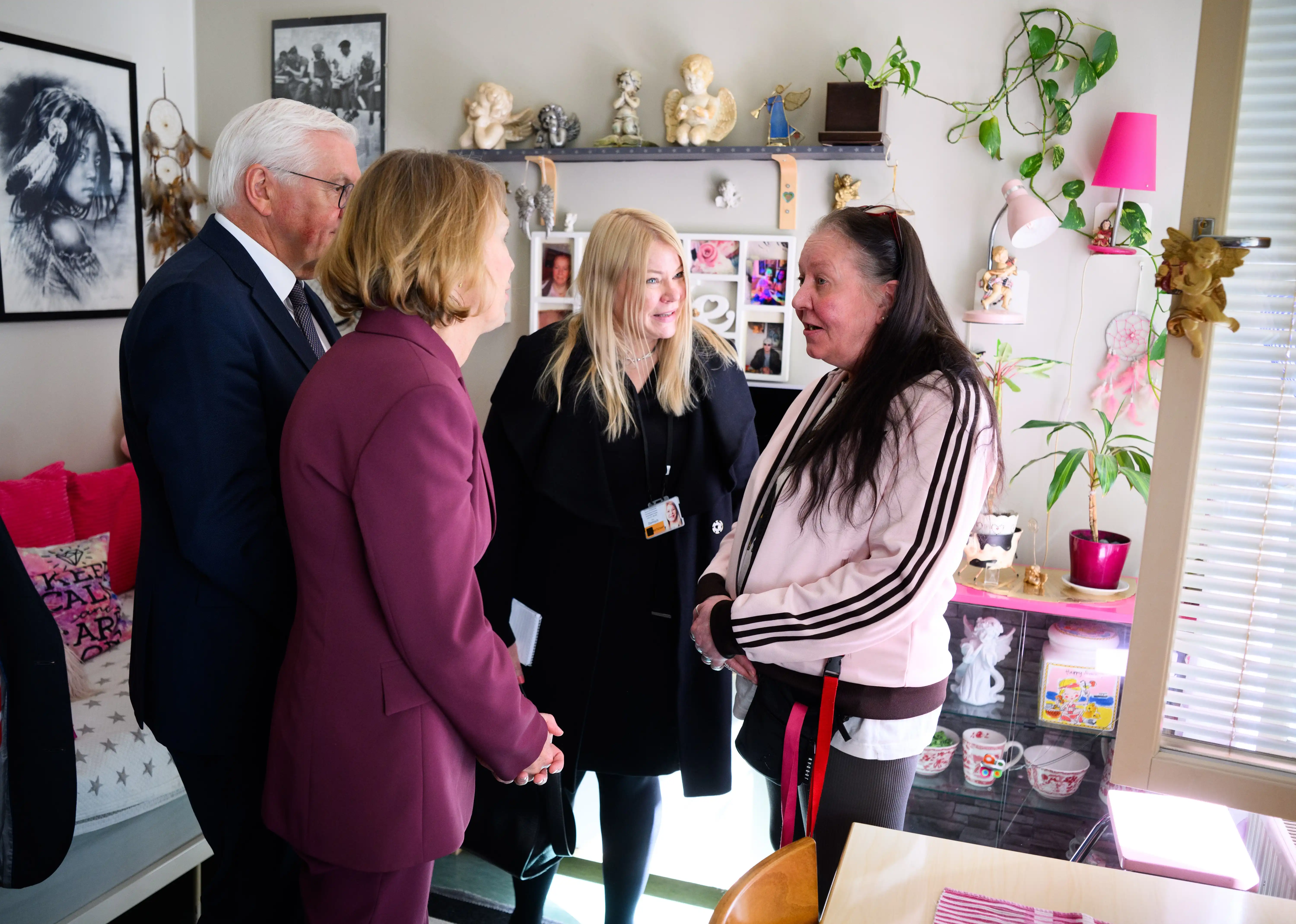 A woman speaks with two government officials in her temporary housing flat