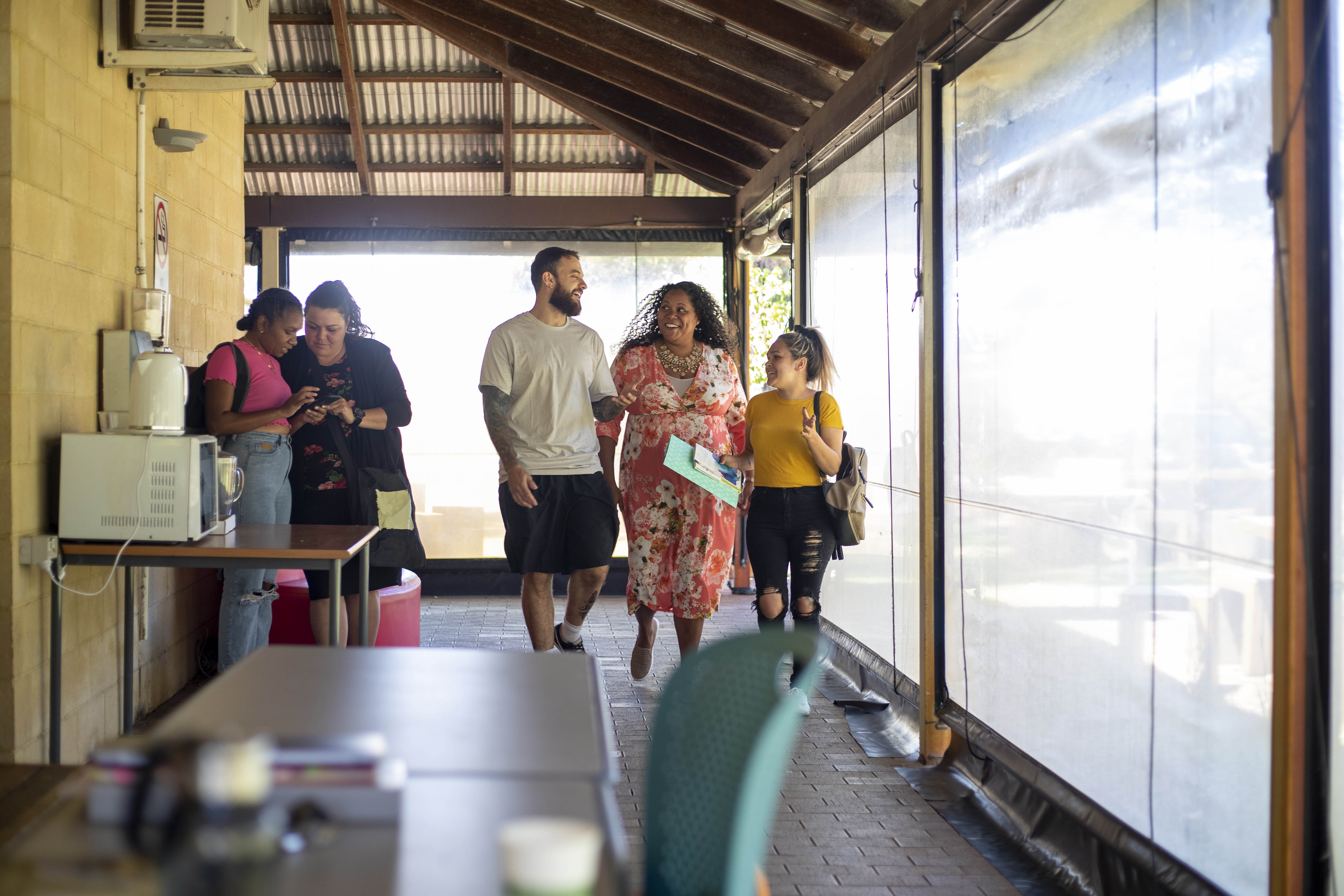 Indigenous students walking down an outdoor corridor