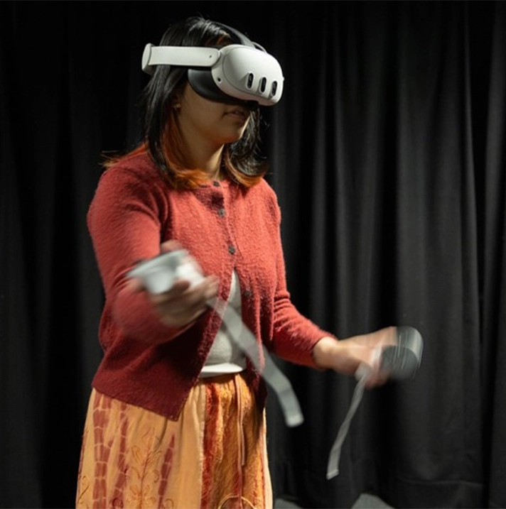 A woman waves her arms while wearing a VR headset