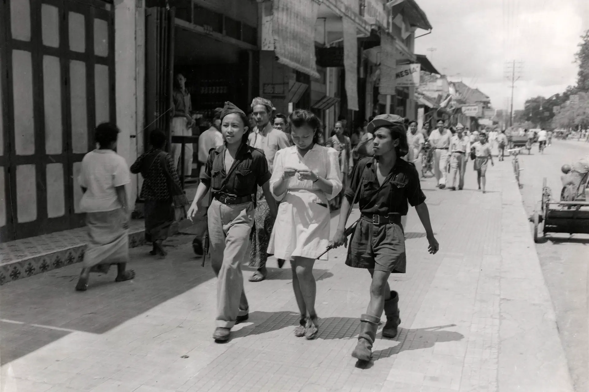 Old photo of three Indonesian women walking down a street