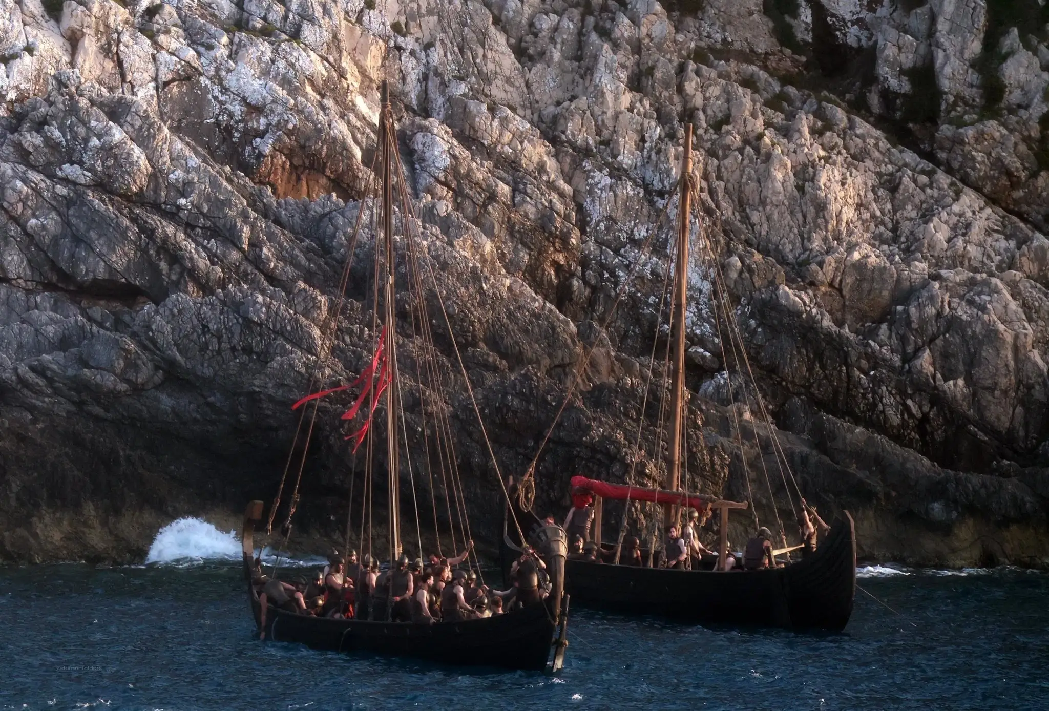 Two Greek boats with soldiers aboard near a cliff face