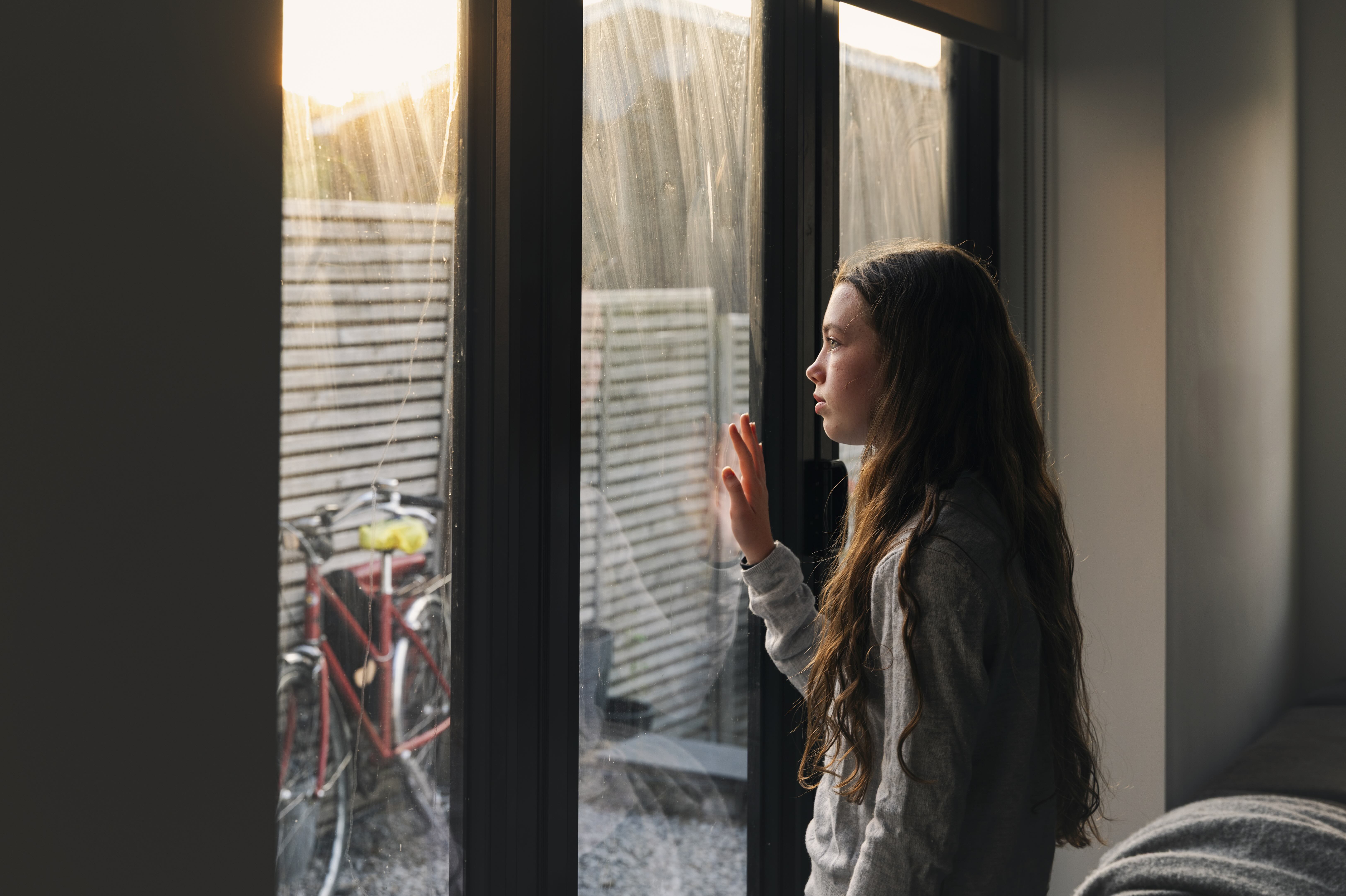 Social media ban Summer_Teen girl looking out window