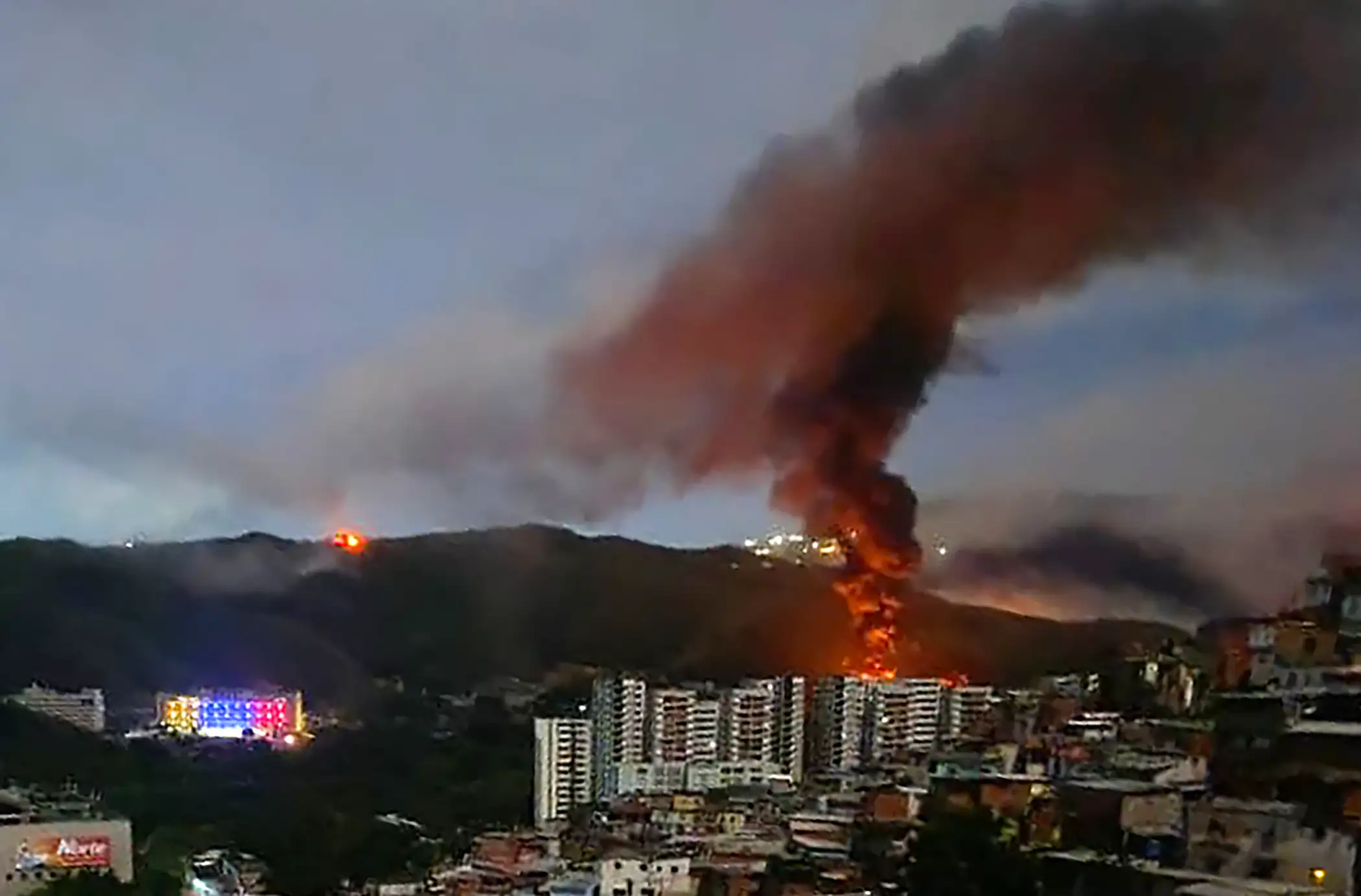 A fire at Fuerte Tiuna, Venezuela's largest military complex, is seen from a distance after a series of explosions.