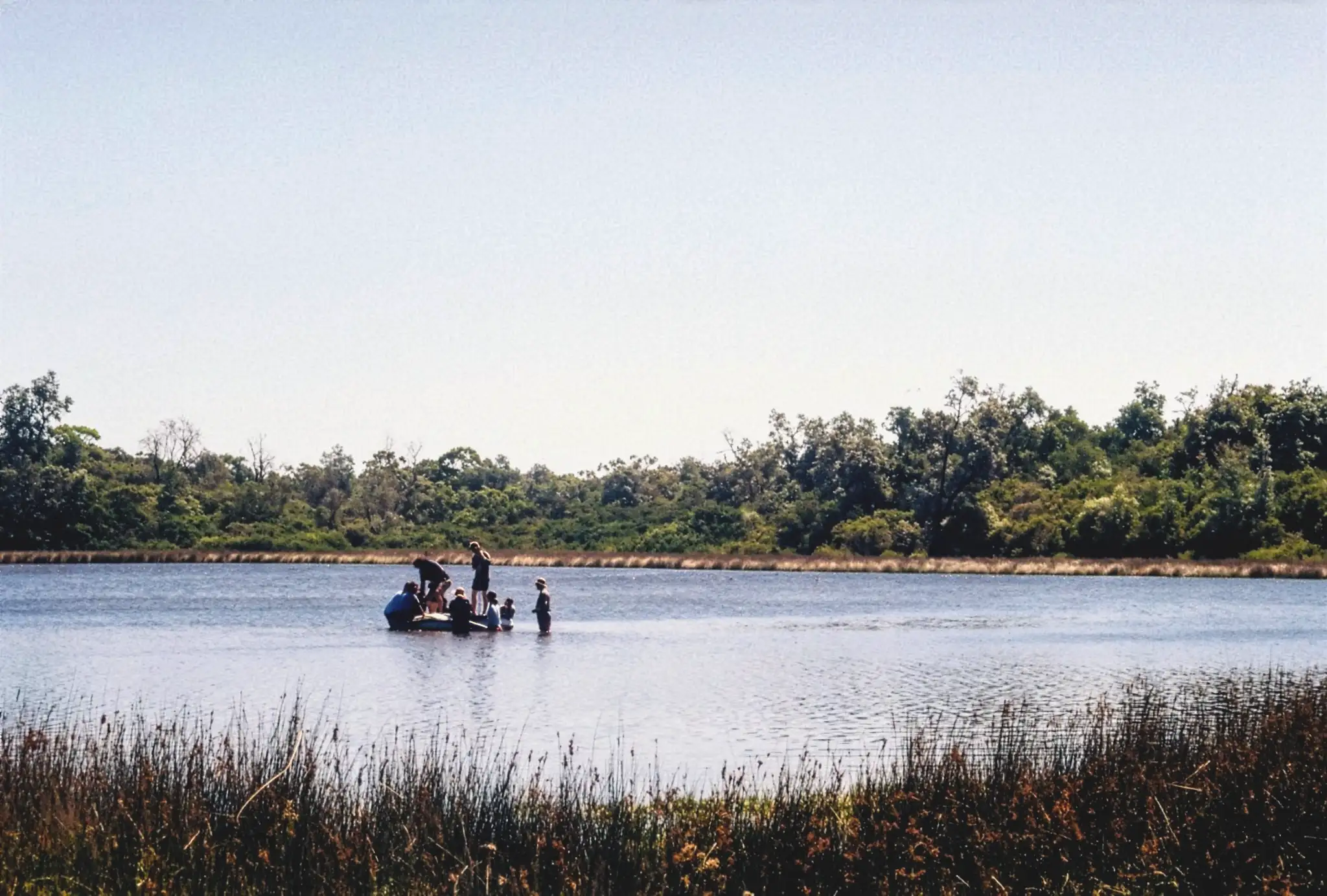 A photo of a group of researchers on a small boat taking core samples