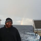 Nathan Teder on a ship with ocean behind
