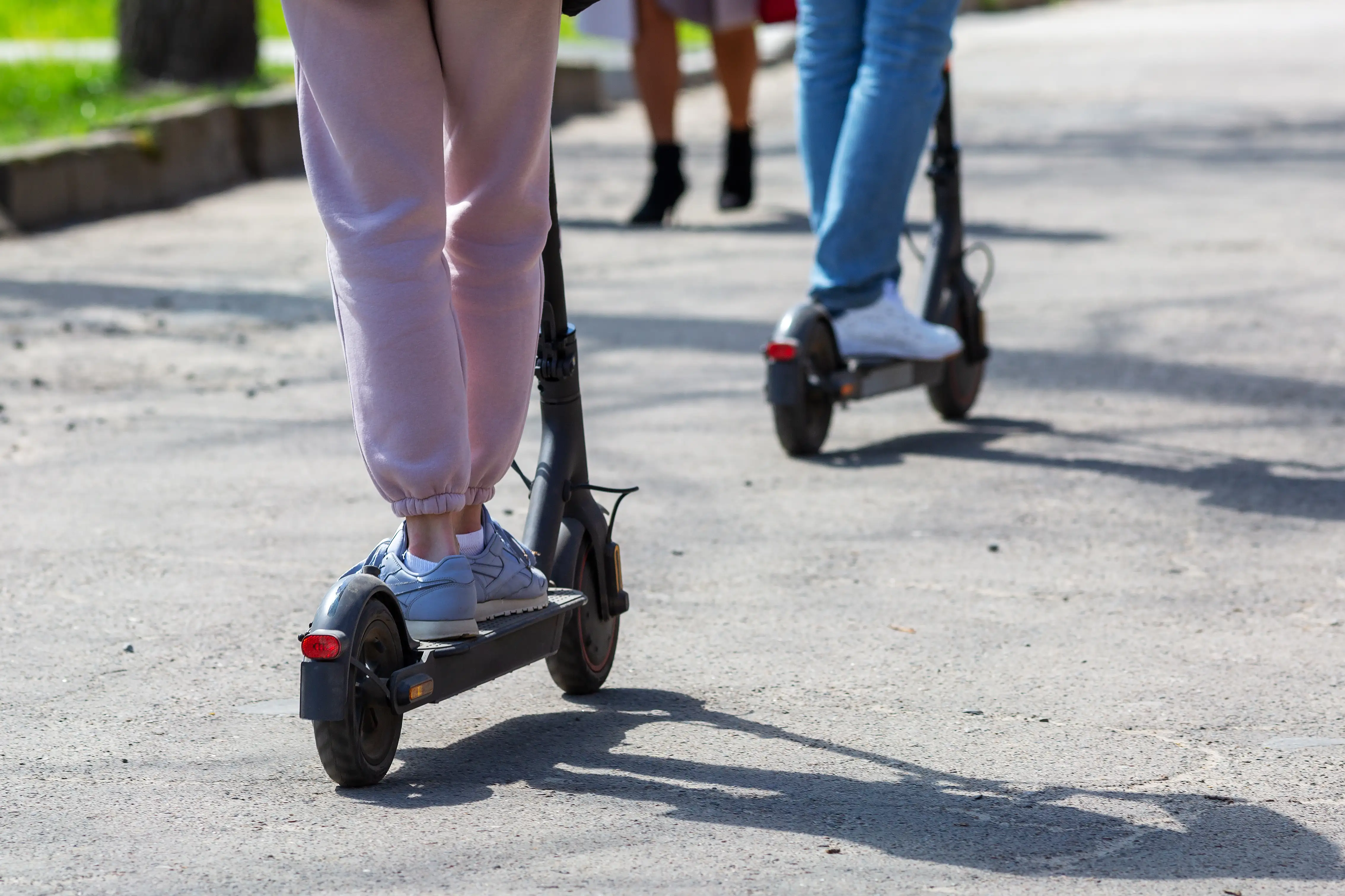 The feet of young girls on an e-scooter