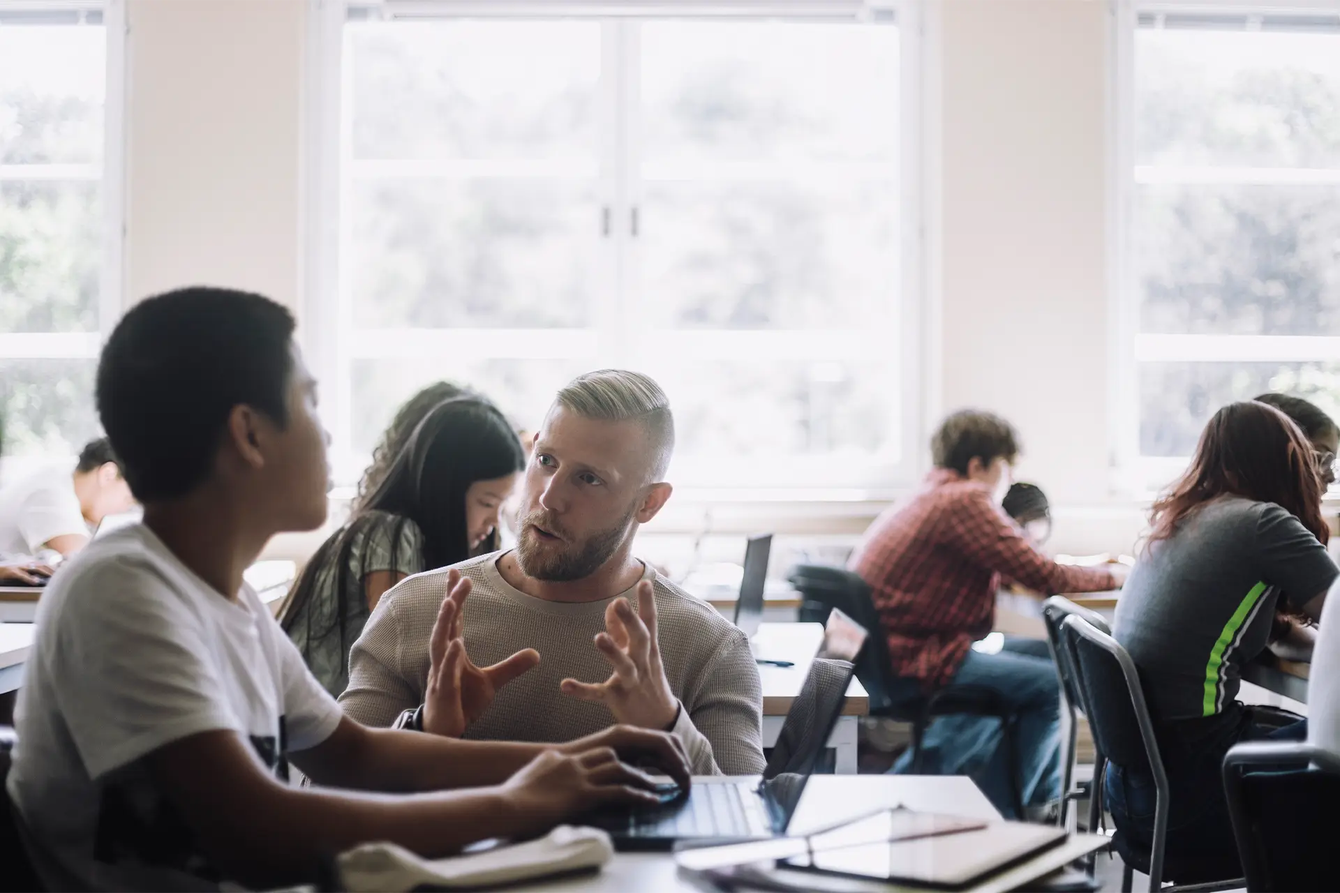 In a classroom a teacher speaks to a student