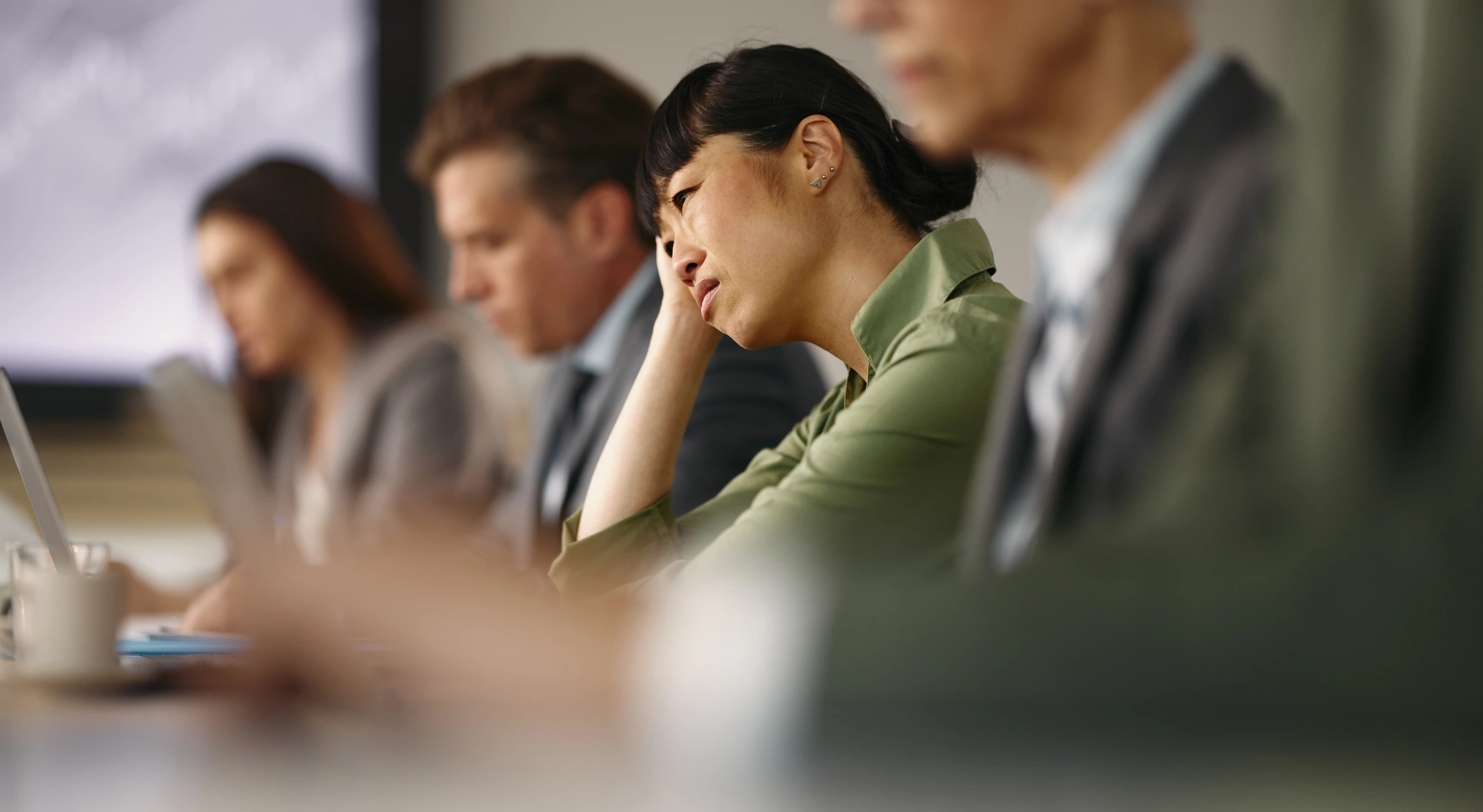 Businesswoman looking confused at her laptop during a meeting