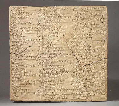 Cracked stone tablet with three columns of ancient writing
