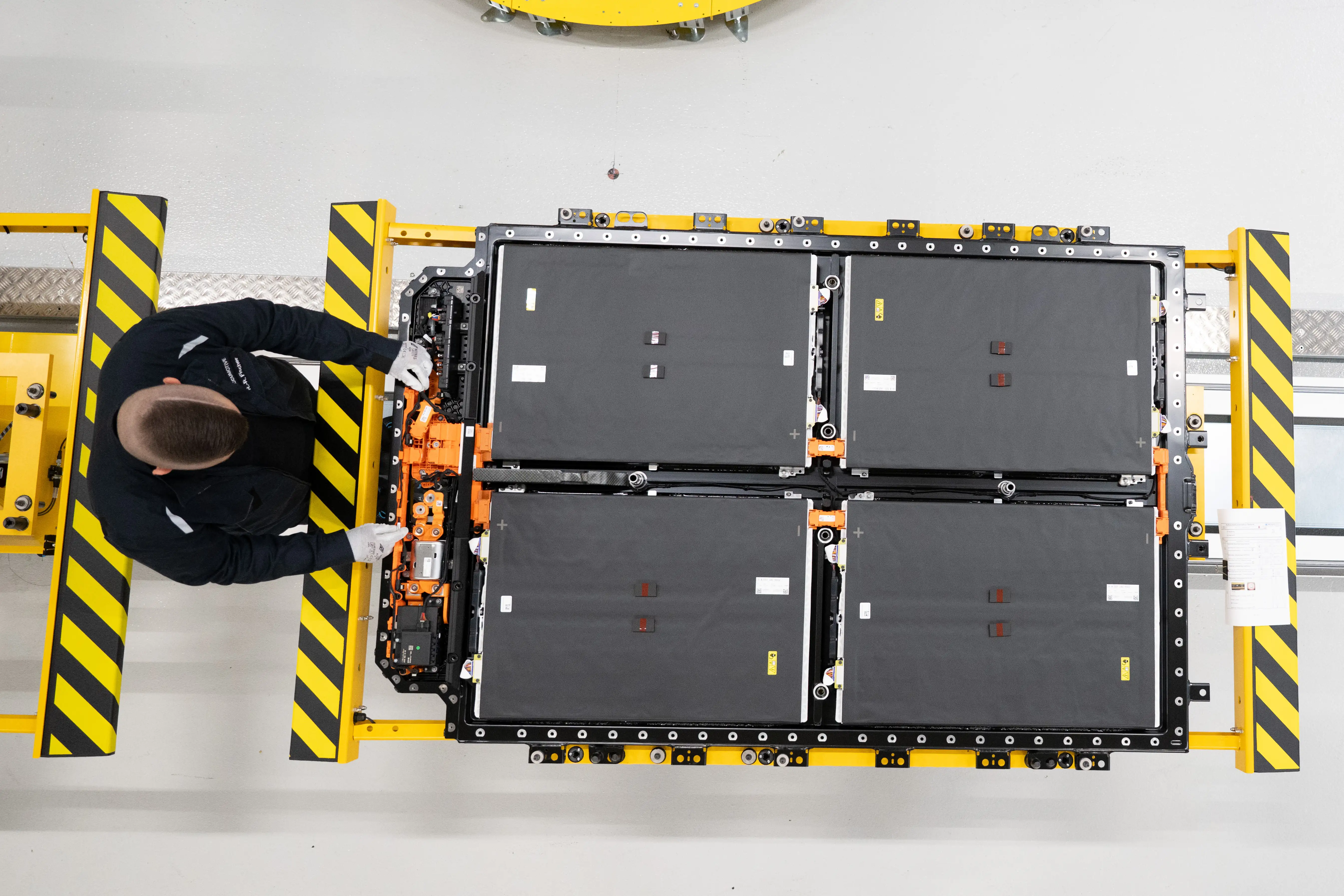 A man working on a production line for battery systems for electric cars.